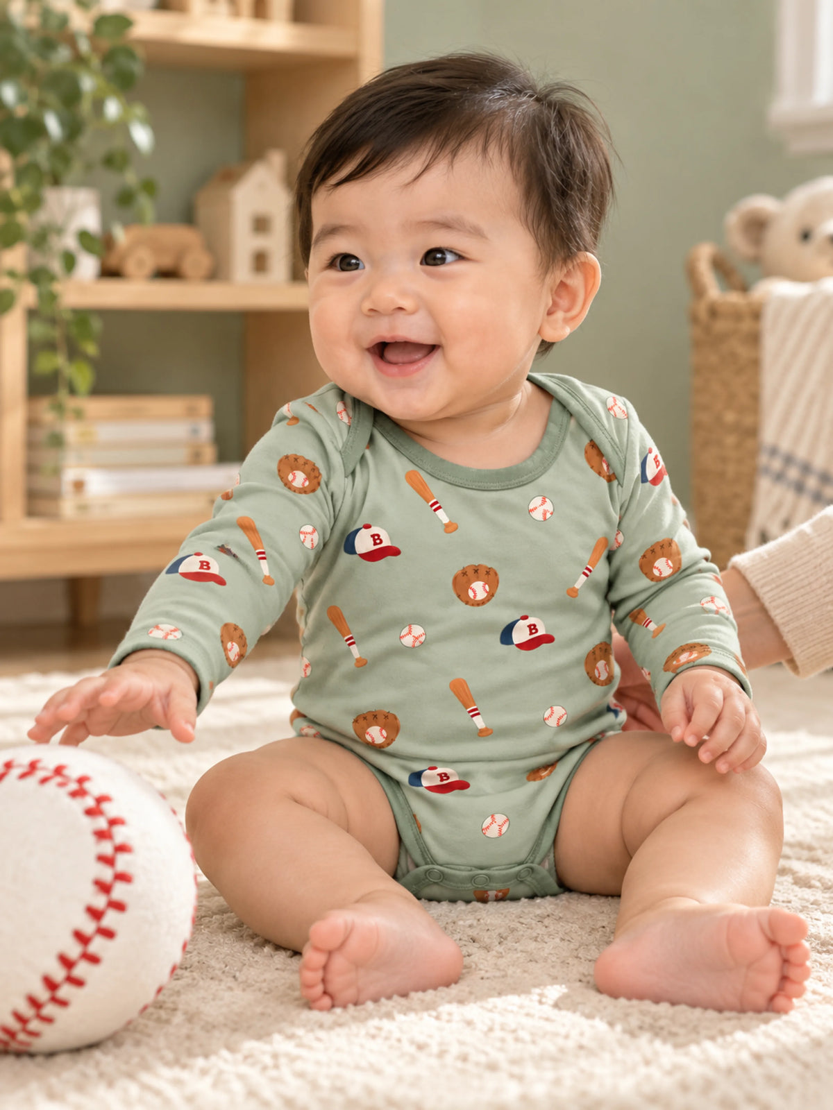 Baby enjoying playtime in Little Sluggers sage green bamboo baseball bodysuit