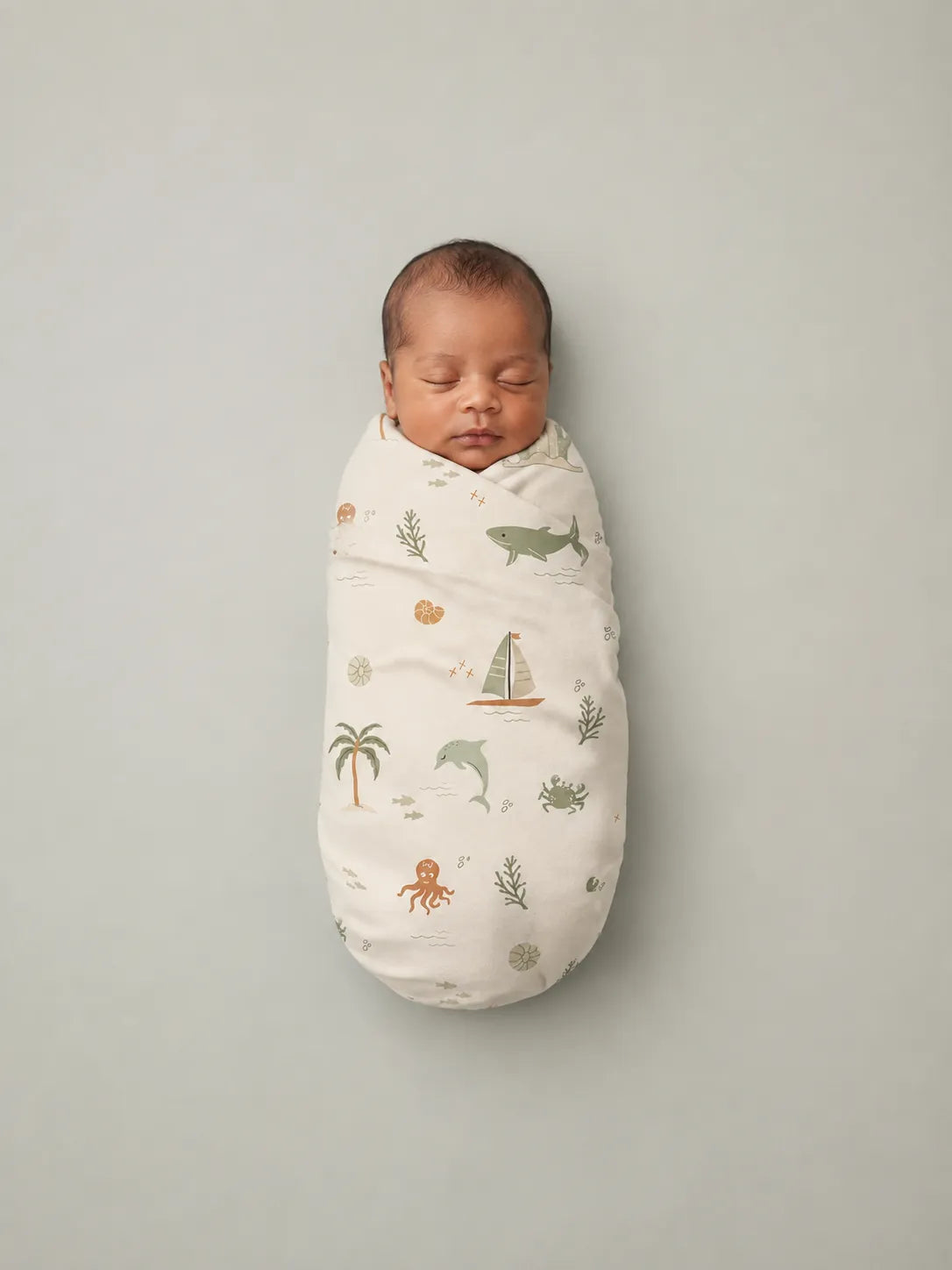 Baby wrapped in the Coastal Friends bamboo swaddle blanket