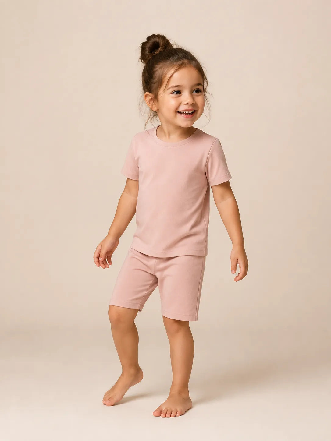 Child wearing Blush Pink bamboo short sleeve pajama set in studio - MossiBaby