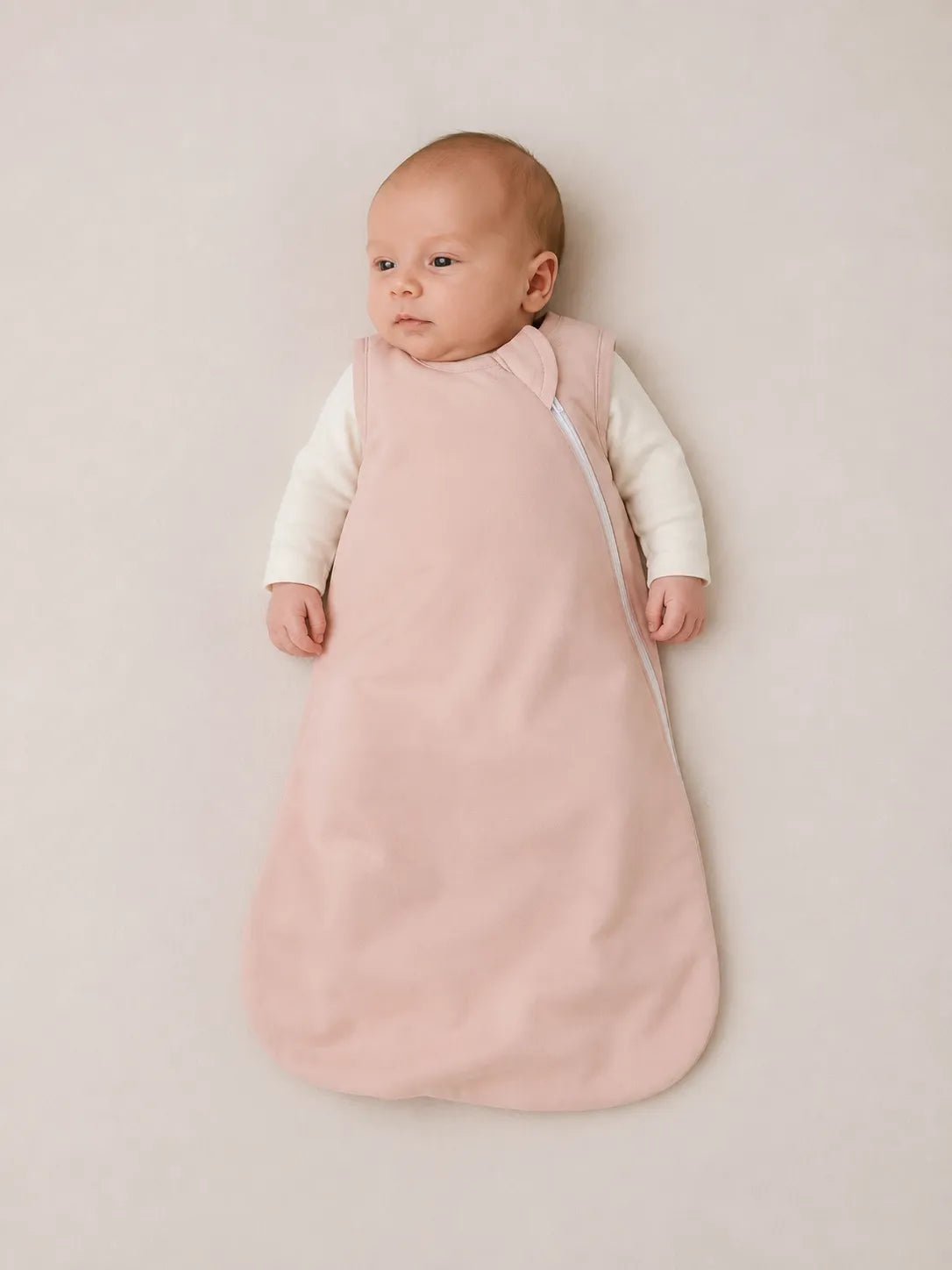 Baby wearing Blush Pink bamboo sleep bag in studio - MossiBaby