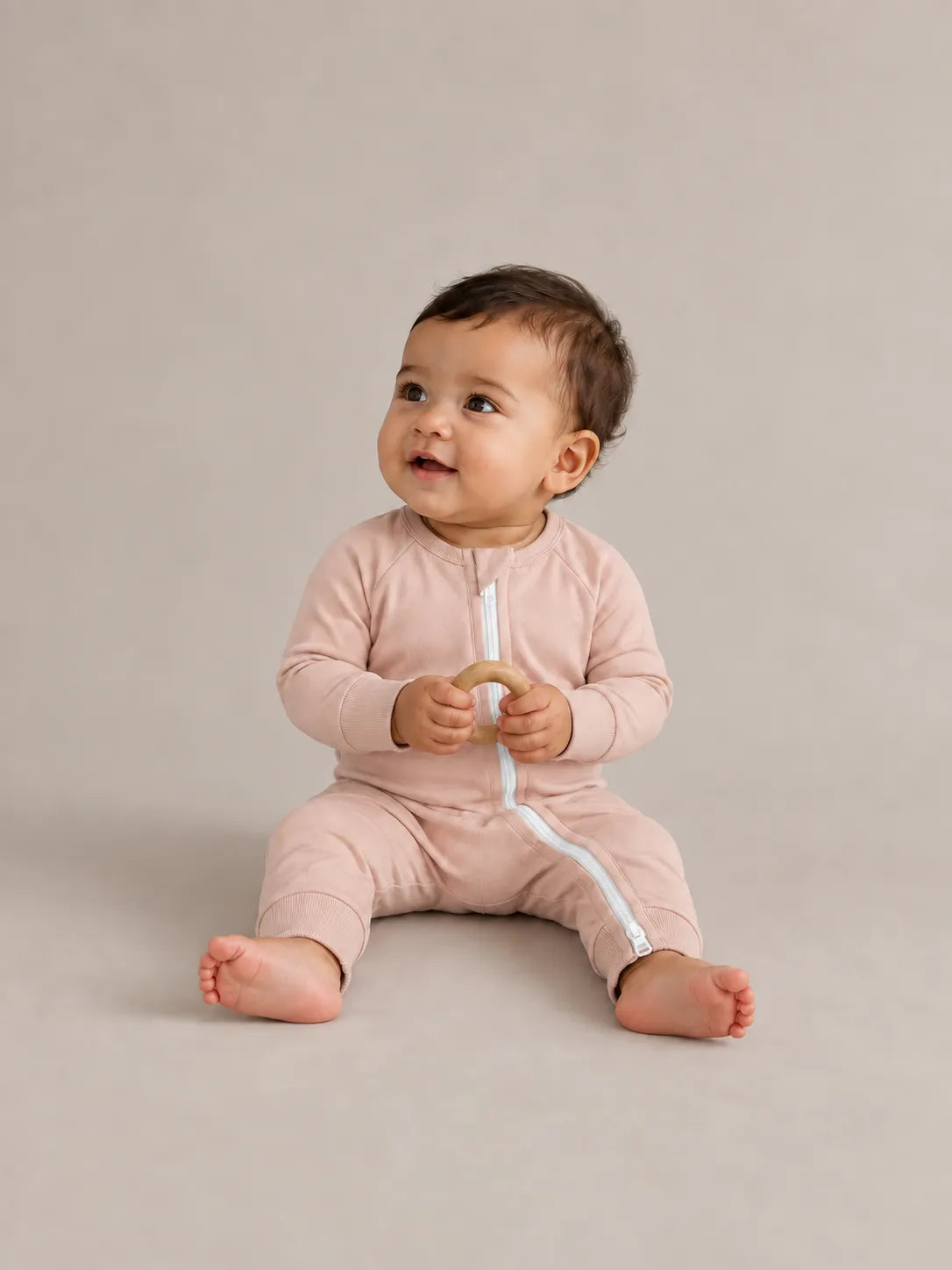 Baby wearing Blush Pink bamboo zipper romper in studio - MossiBaby