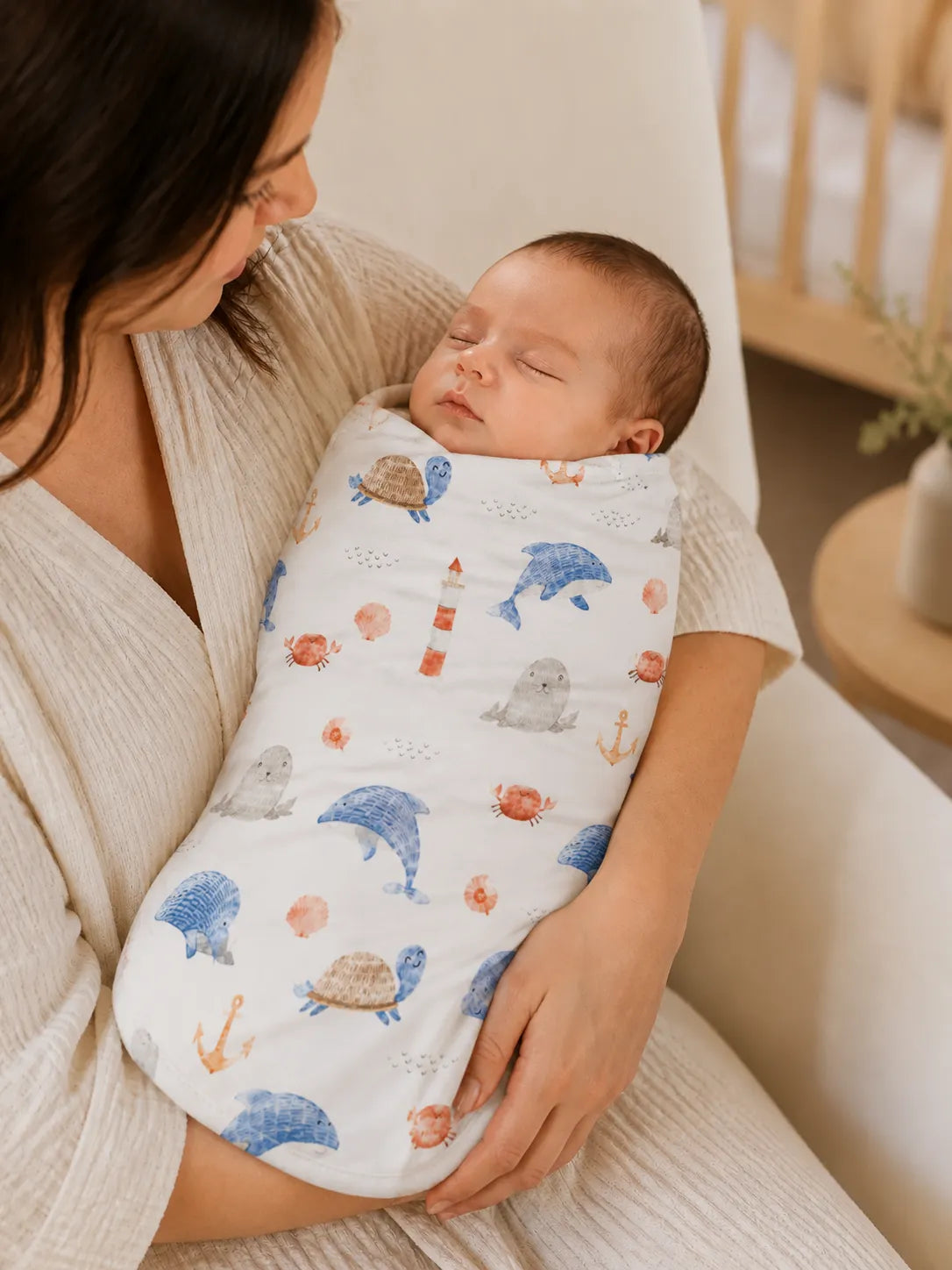 Baby cuddled in the Whale Harbor bamboo swaddle blanket at home