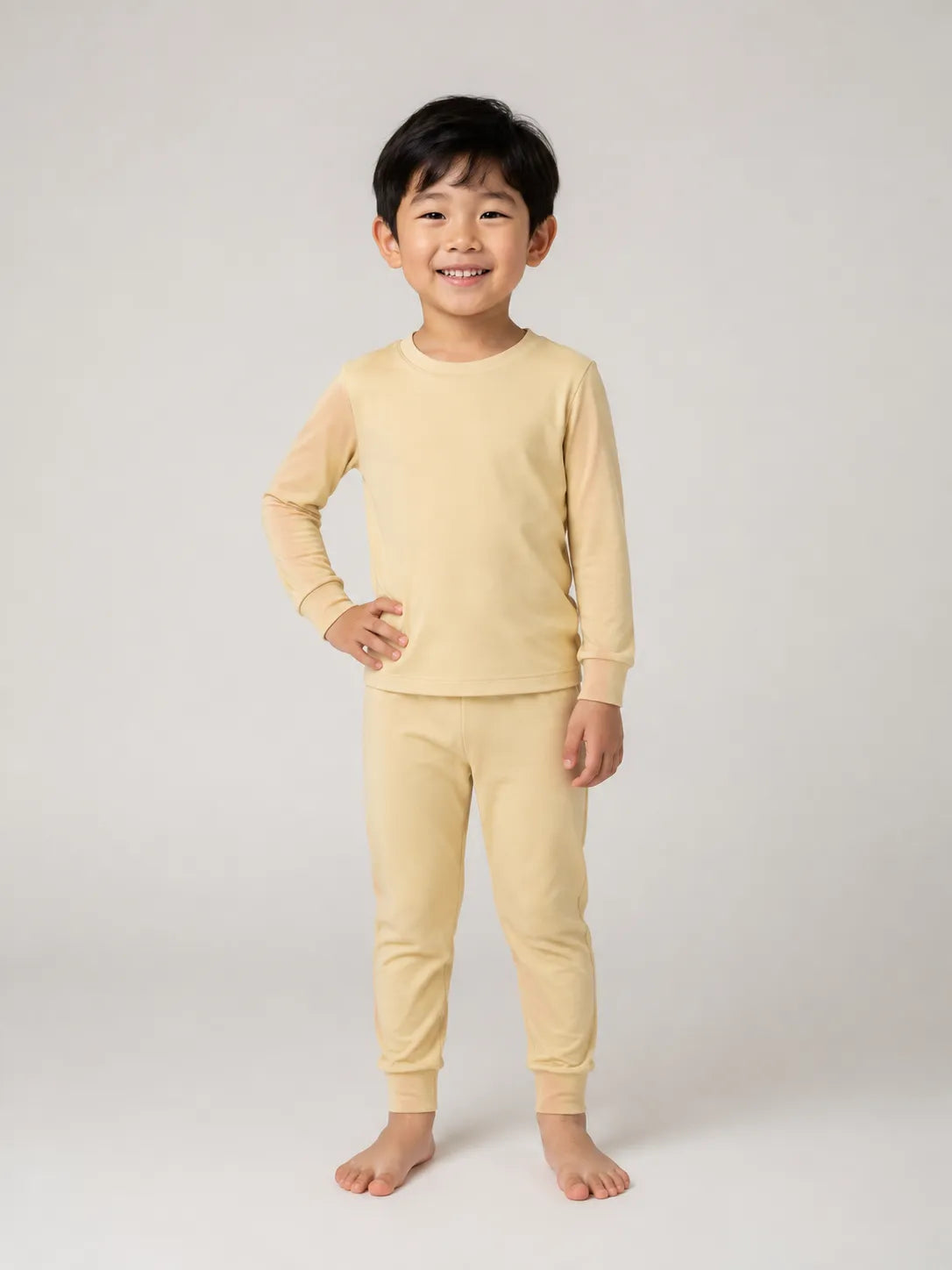 Child wearing Buttercream bamboo long sleeve pajama set in studio - MossiBaby