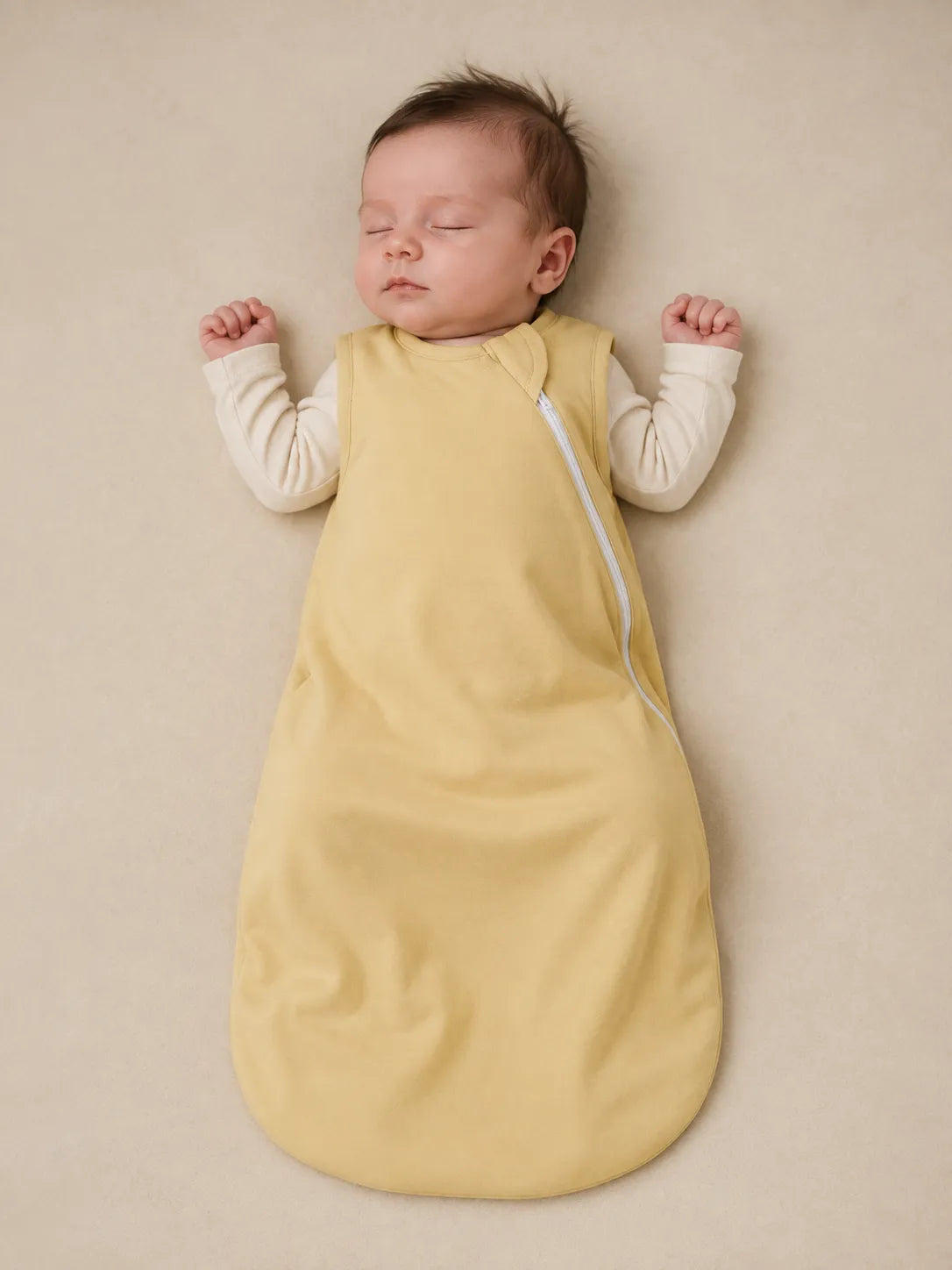 Baby wearing Buttercream bamboo sleep bag in studio - MossiBaby