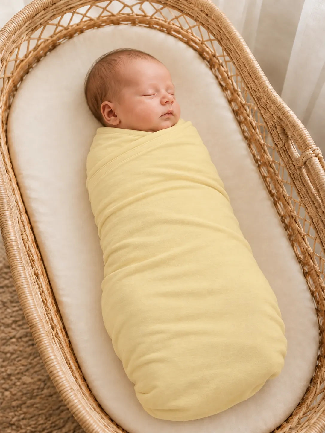 Baby wrapped in Buttercream bamboo swaddle blanket in studio - MossiBaby