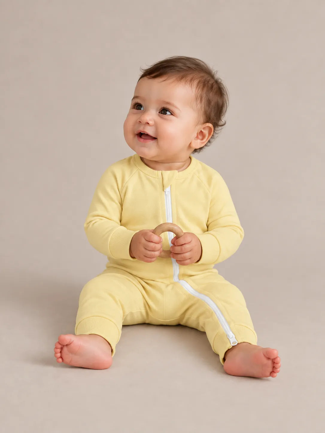 Baby wearing Buttercream bamboo zipper romper in studio - MossiBaby