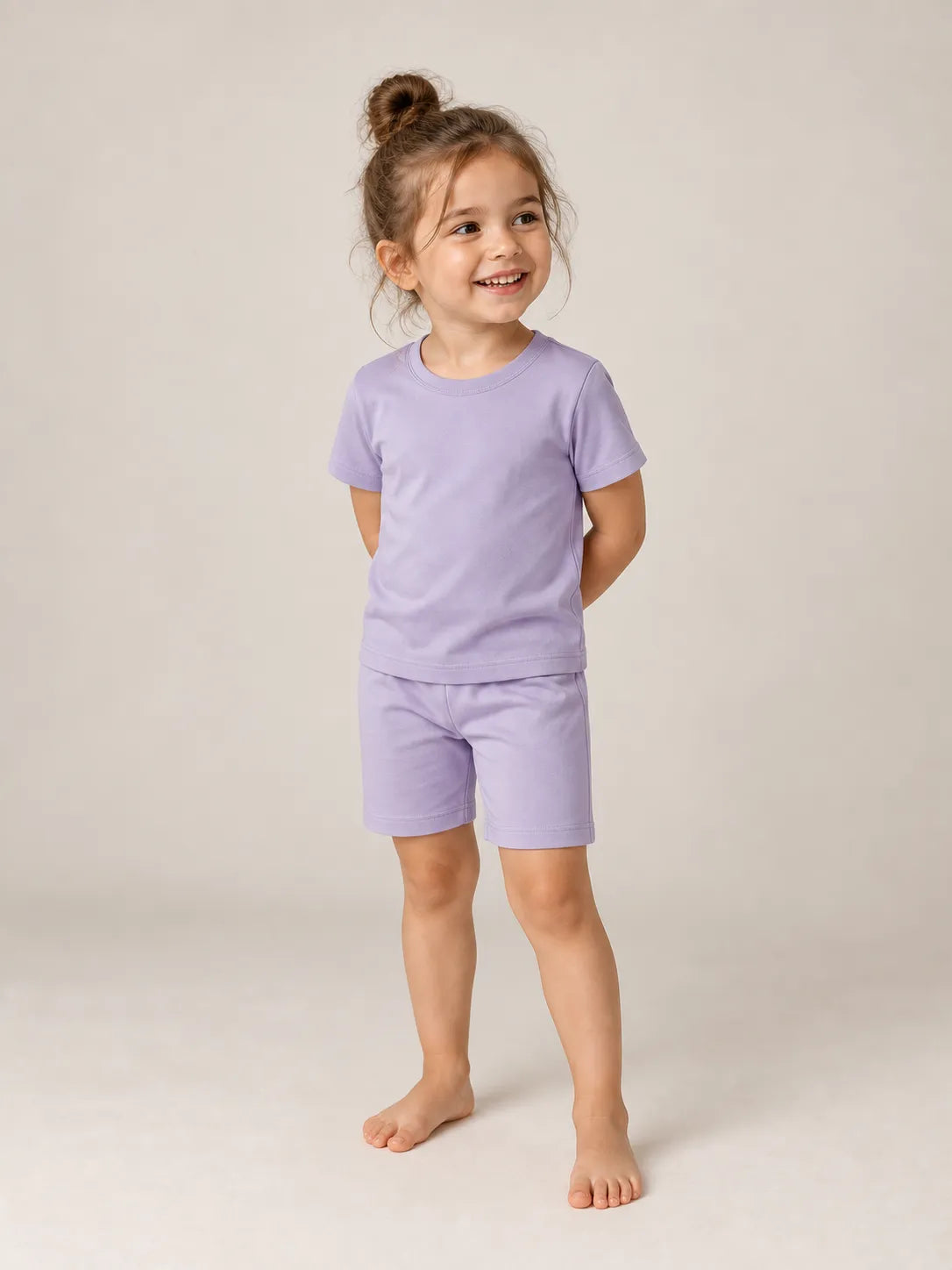 Child wearing Lavender bamboo short sleeve pajama set in studio - MossiBaby
