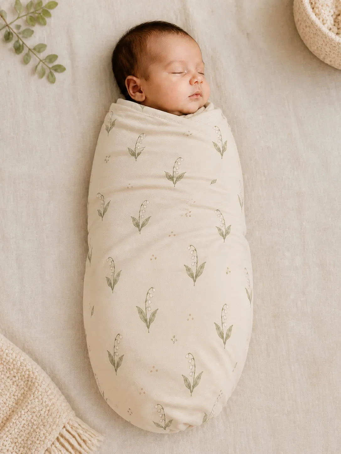Baby wrapped in the Little Botanicals bamboo swaddle blanket