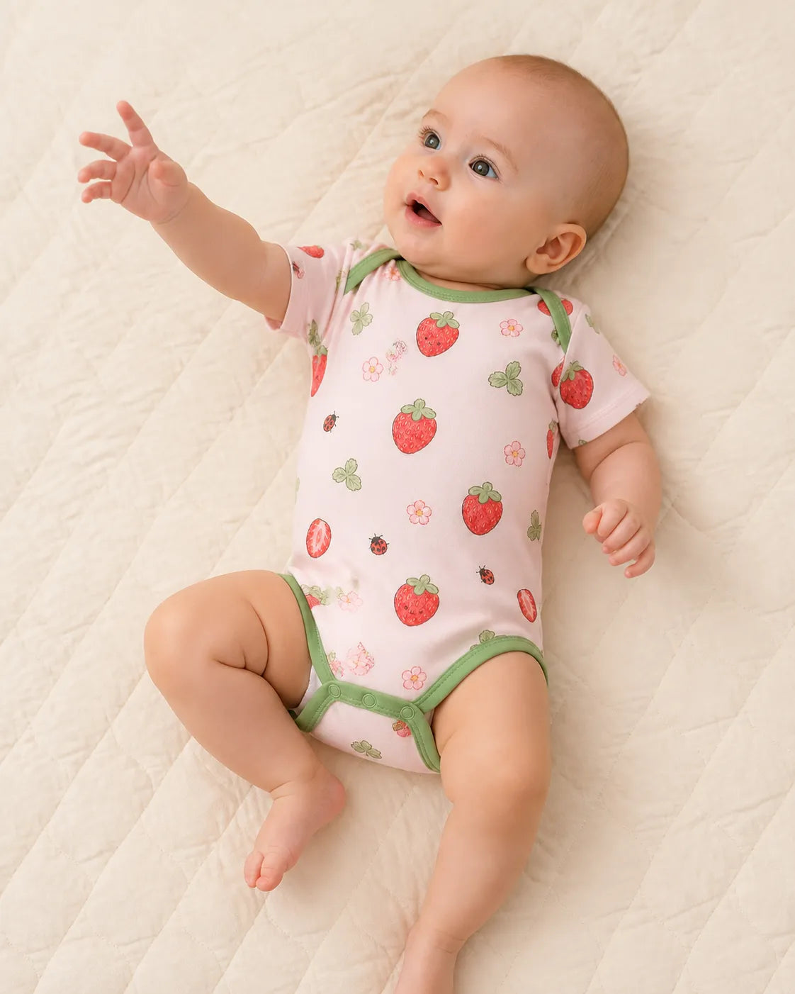 Baby playing comfortably in the Strawberry Fields bamboo bodysuit