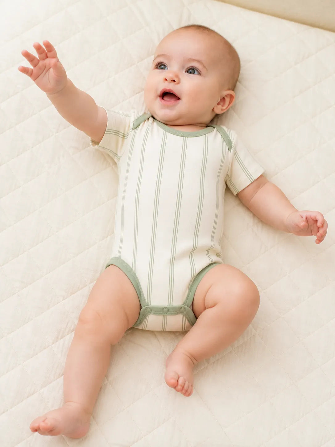 Baby playing comfortably in the Sage Stripe bamboo bodysuit