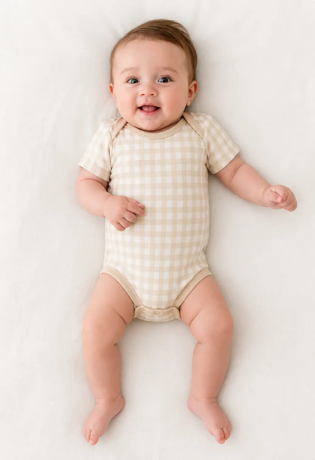 Baby wearing the Oat Gingham short sleeve bodysuit