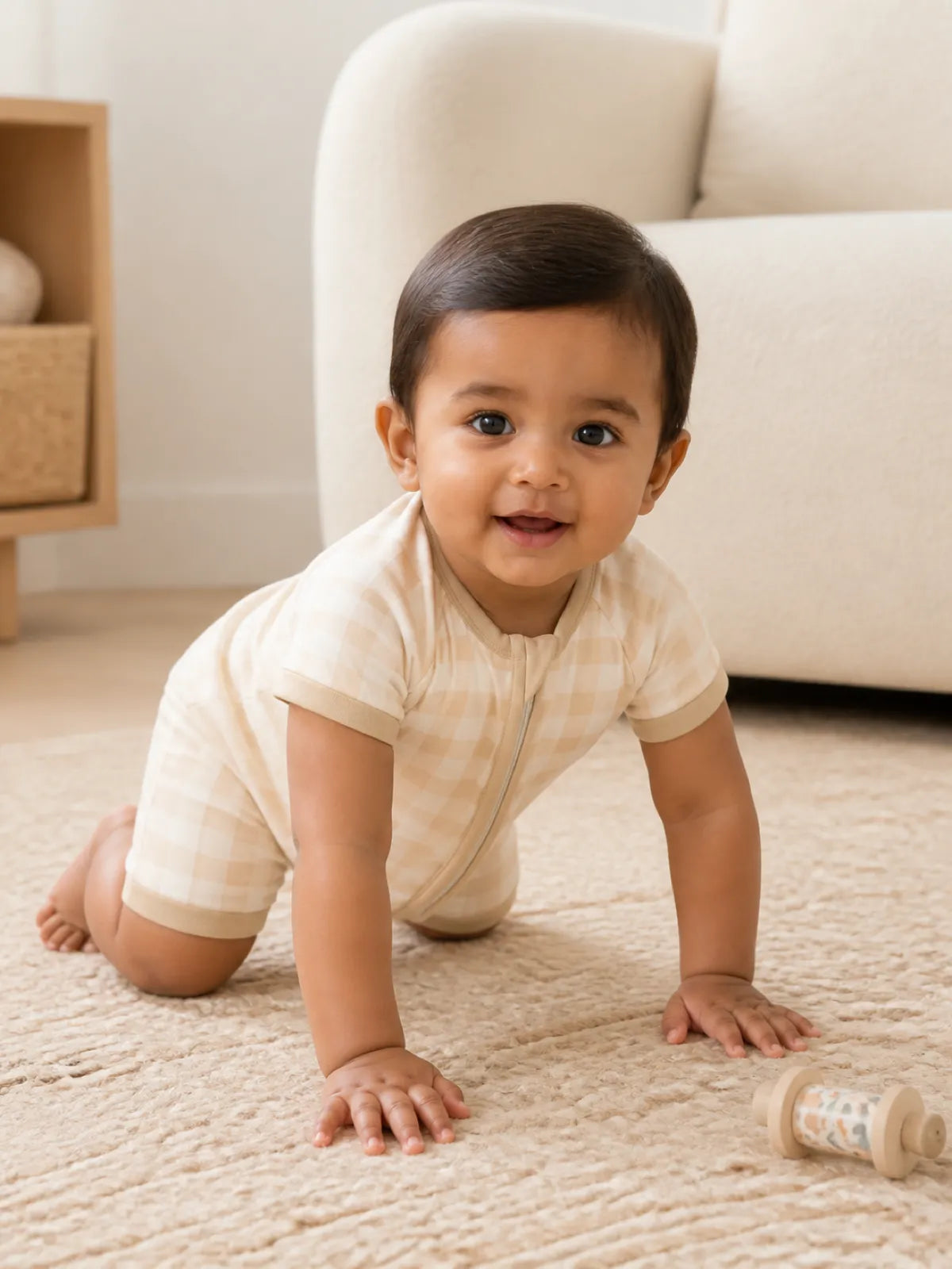 Baby playing at home in the Oat Gingham shorty romper