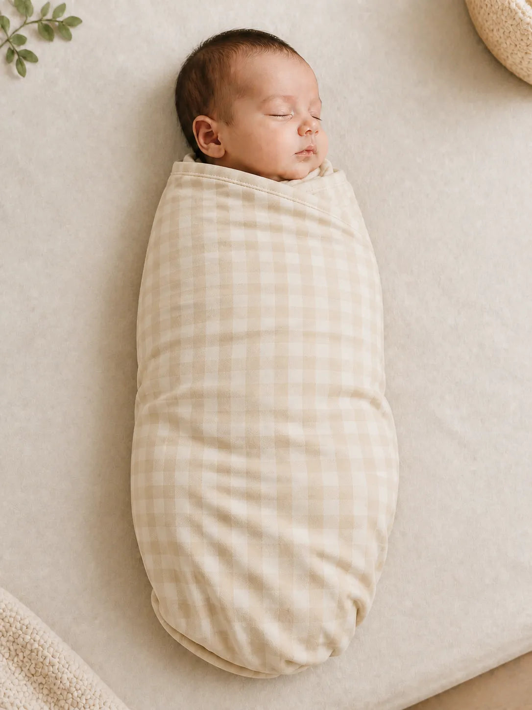 Baby wrapped in the Oat Gingham bamboo swaddle blanket