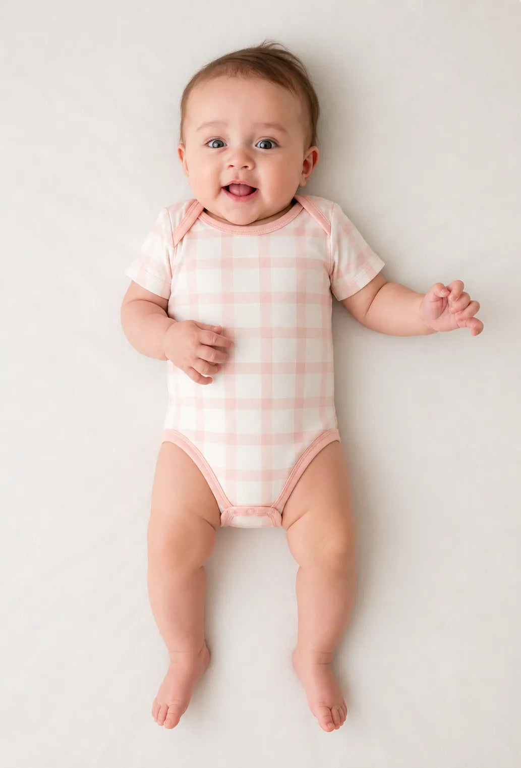 Baby wearing the Blush Plaid short sleeve bodysuit