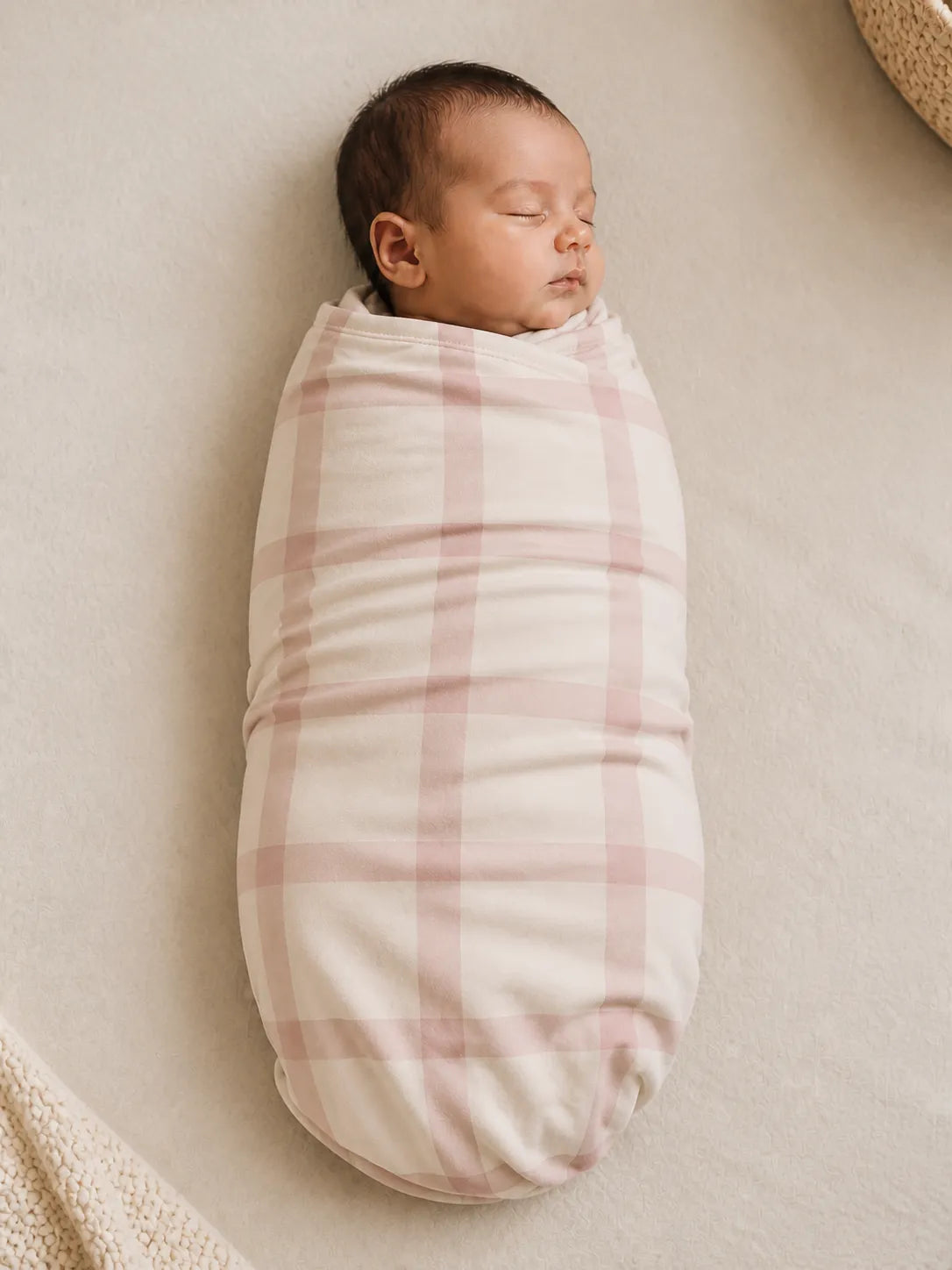 Baby wrapped in the Blush Plaid bamboo swaddle blanket