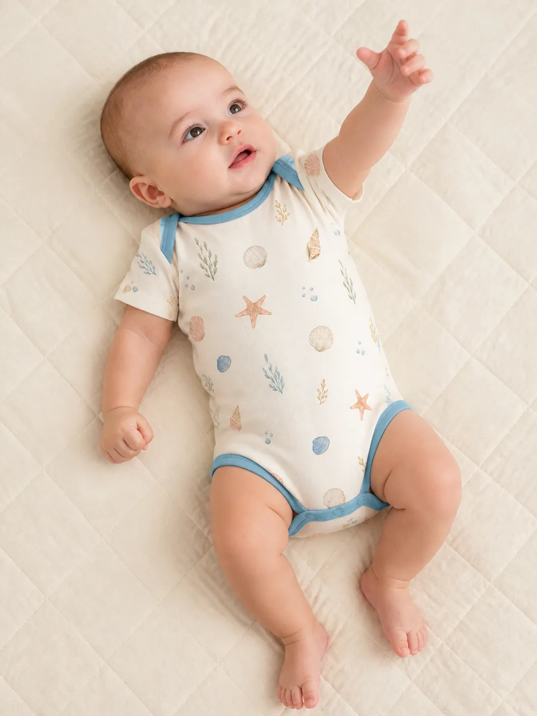 Baby playing comfortably in the Seaside Treasures bamboo bodysuit
