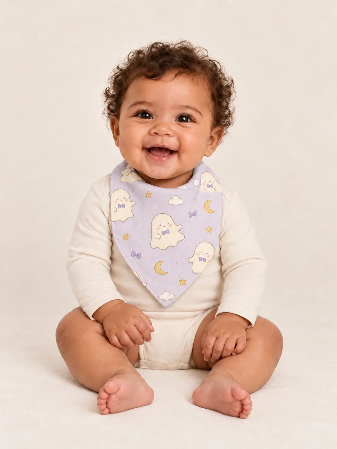 Baby wearing the MossiBaby Boo & Moon bandana bib with an ivory long-sleeve bodysuit