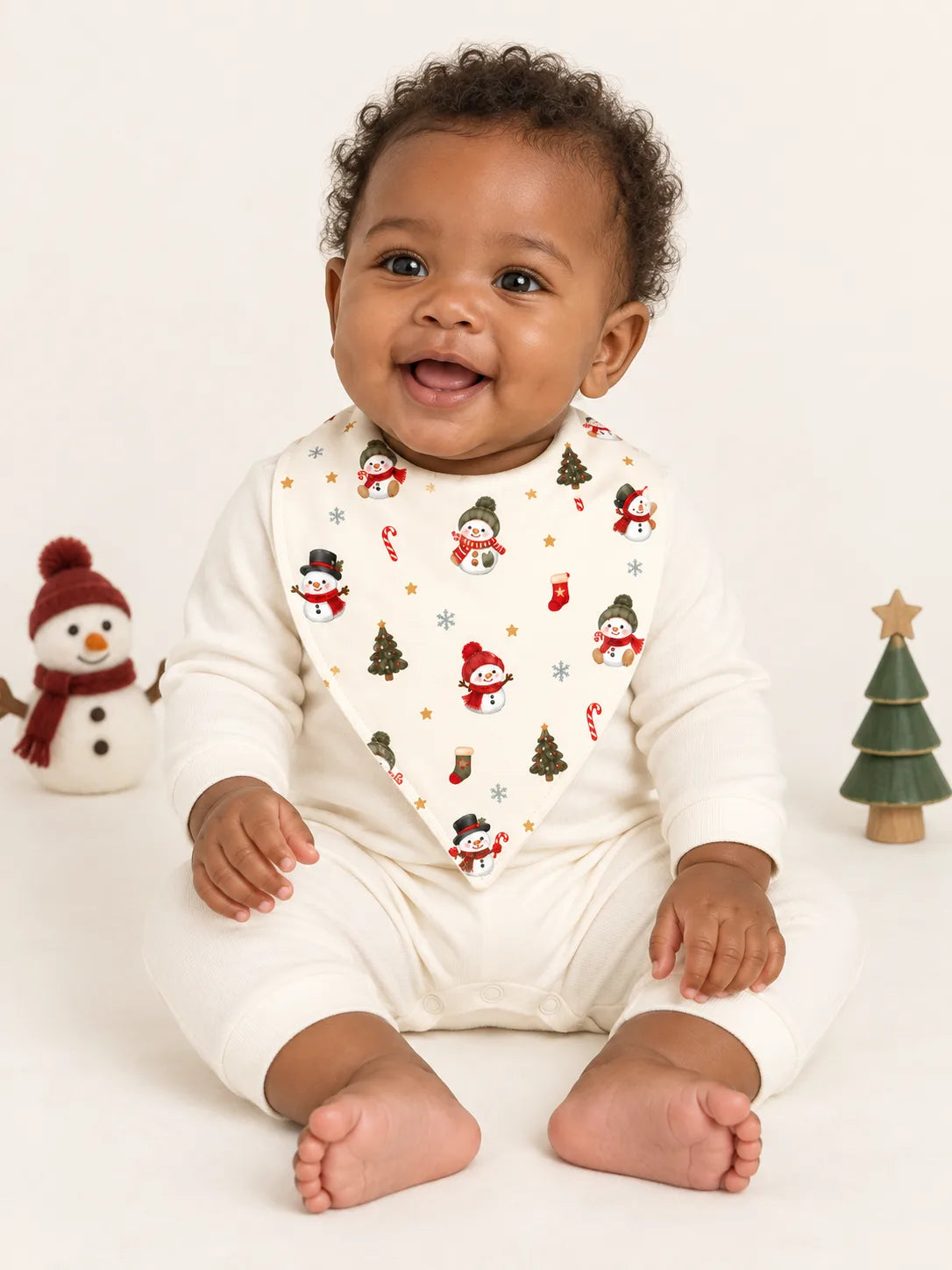 Baby sitting in a studio wearing Mossibaby Christmas Snowman ivory cream bamboo bandana bib
