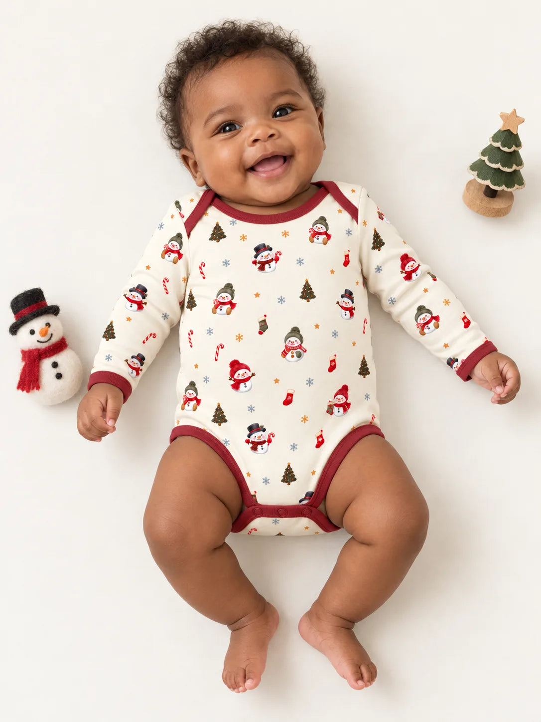Baby lying on a studio mat wearing Mossibaby Christmas Snowman ivory cream bamboo long sleeve bodysuit with cranberry red trim