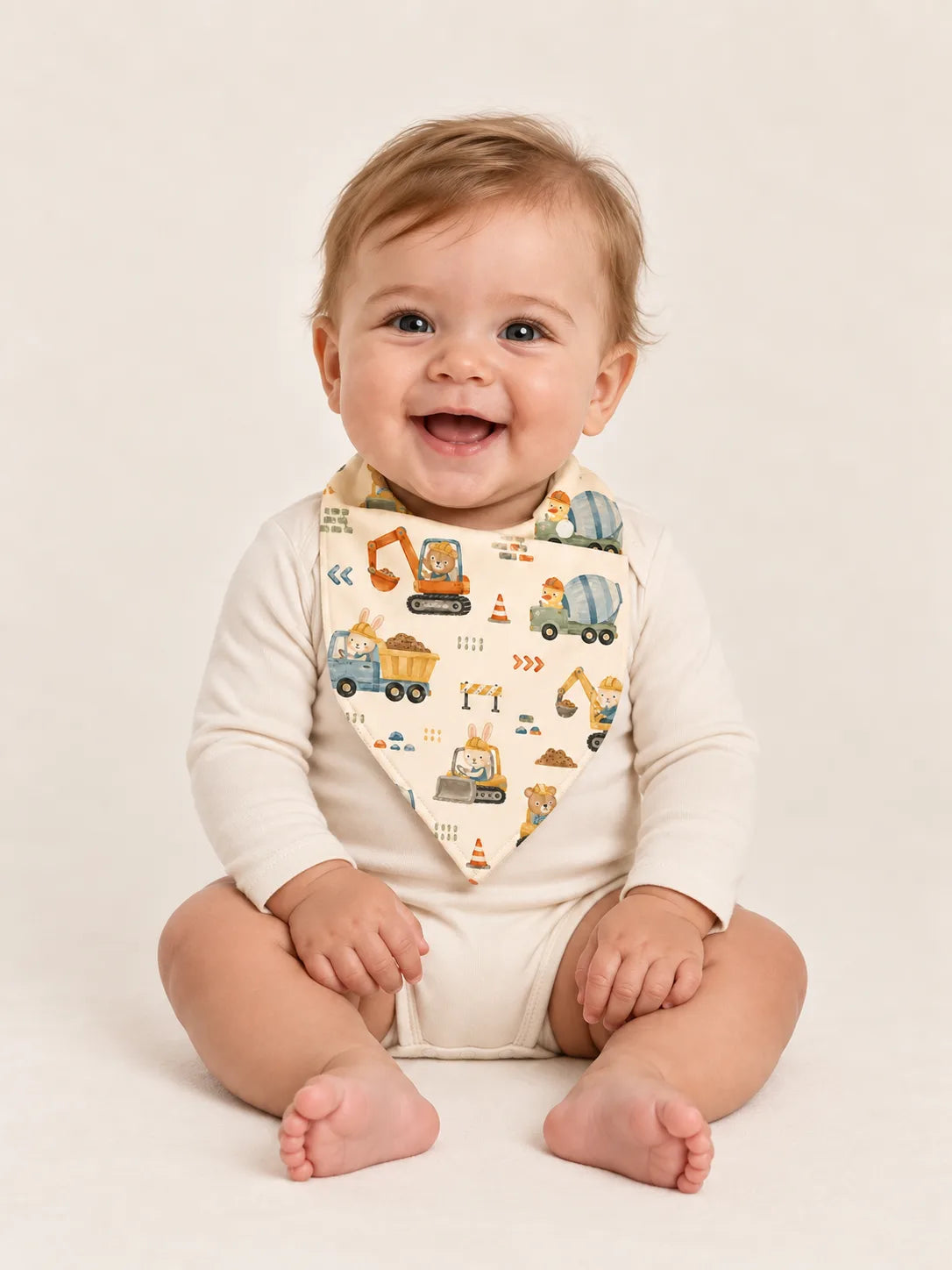 Baby wearing the MossiBaby Construction Crew bandana bib with an ivory long-sleeve bodysuit