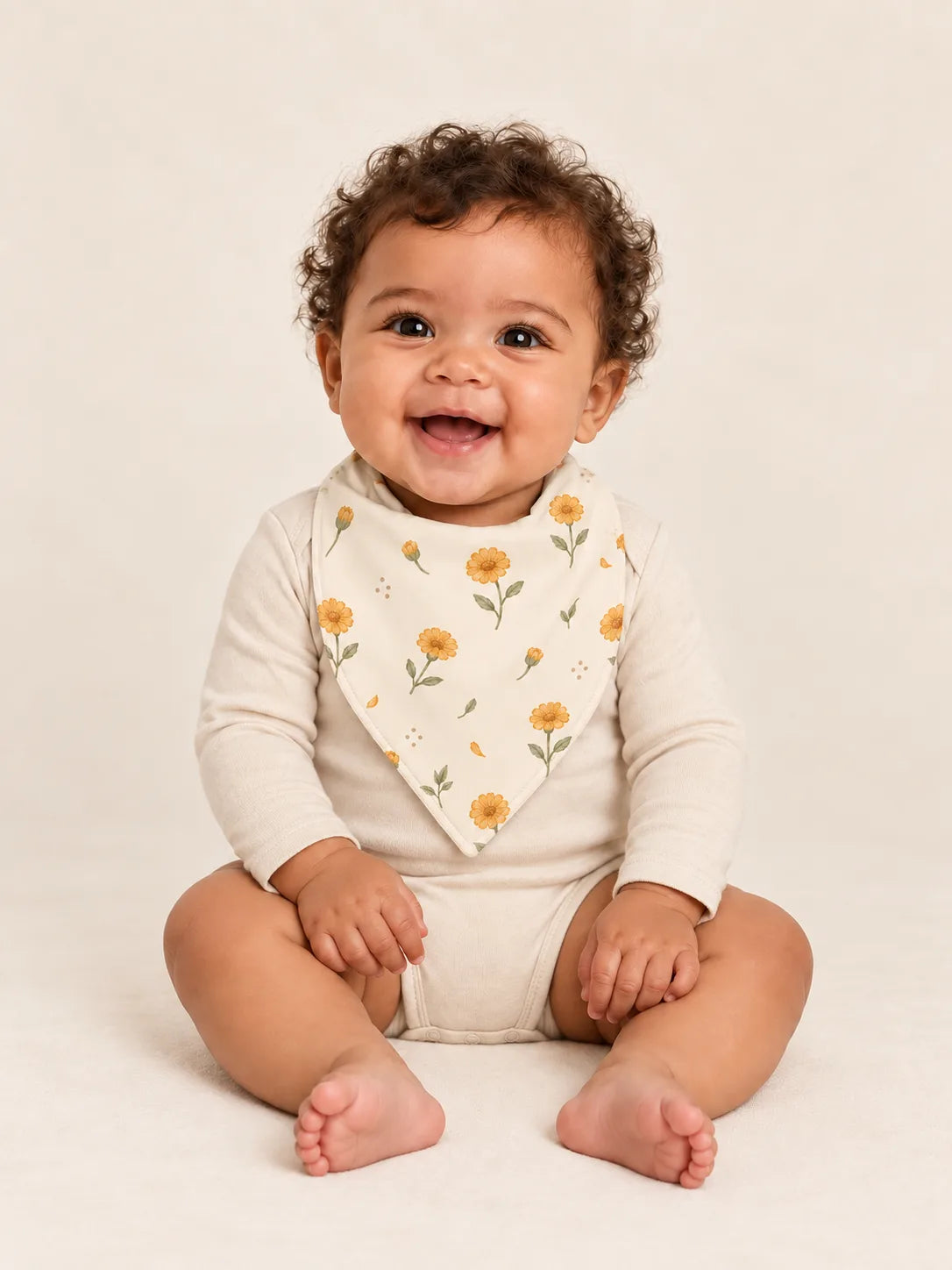 Baby wearing the MossiBaby Golden Bloom bandana bib with an ivory long-sleeve bodysuit