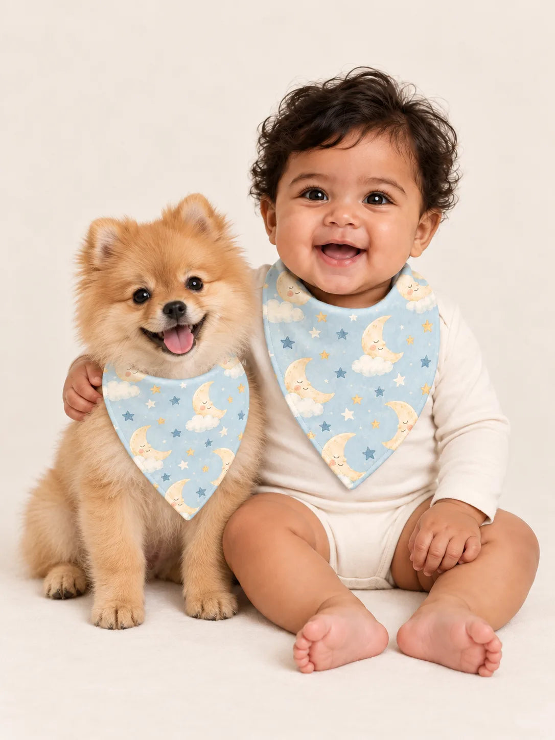 Baby and Pomeranian puppy wearing matching MossiBaby Moonlit Dreams bandana bibs