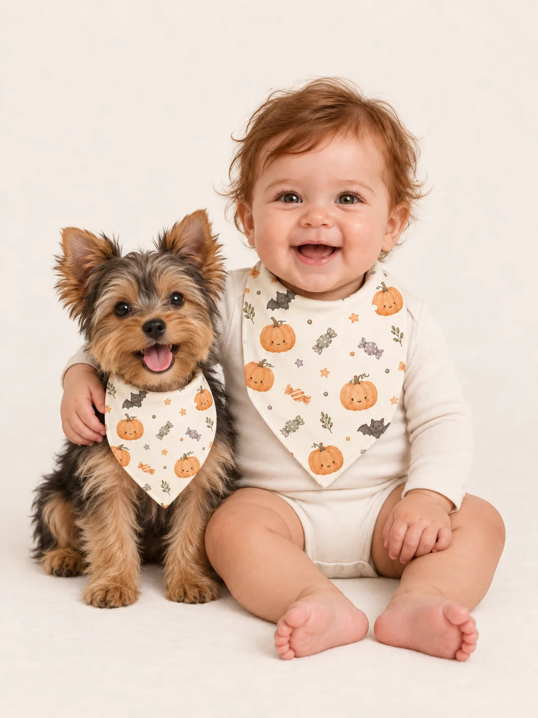Baby and Yorkshire Terrier puppy wearing matching MossiBaby Pumpkin Treats bandana bibs