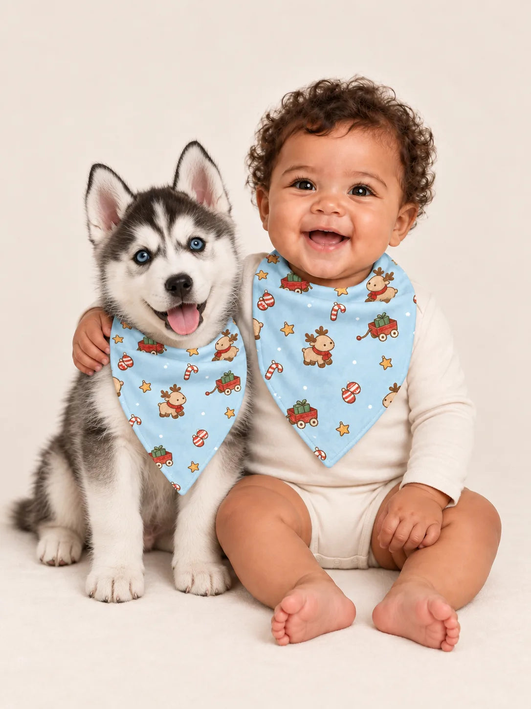Baby and Siberian Husky puppy wearing matching MossiBaby Reindeer Ride bandana bibs
