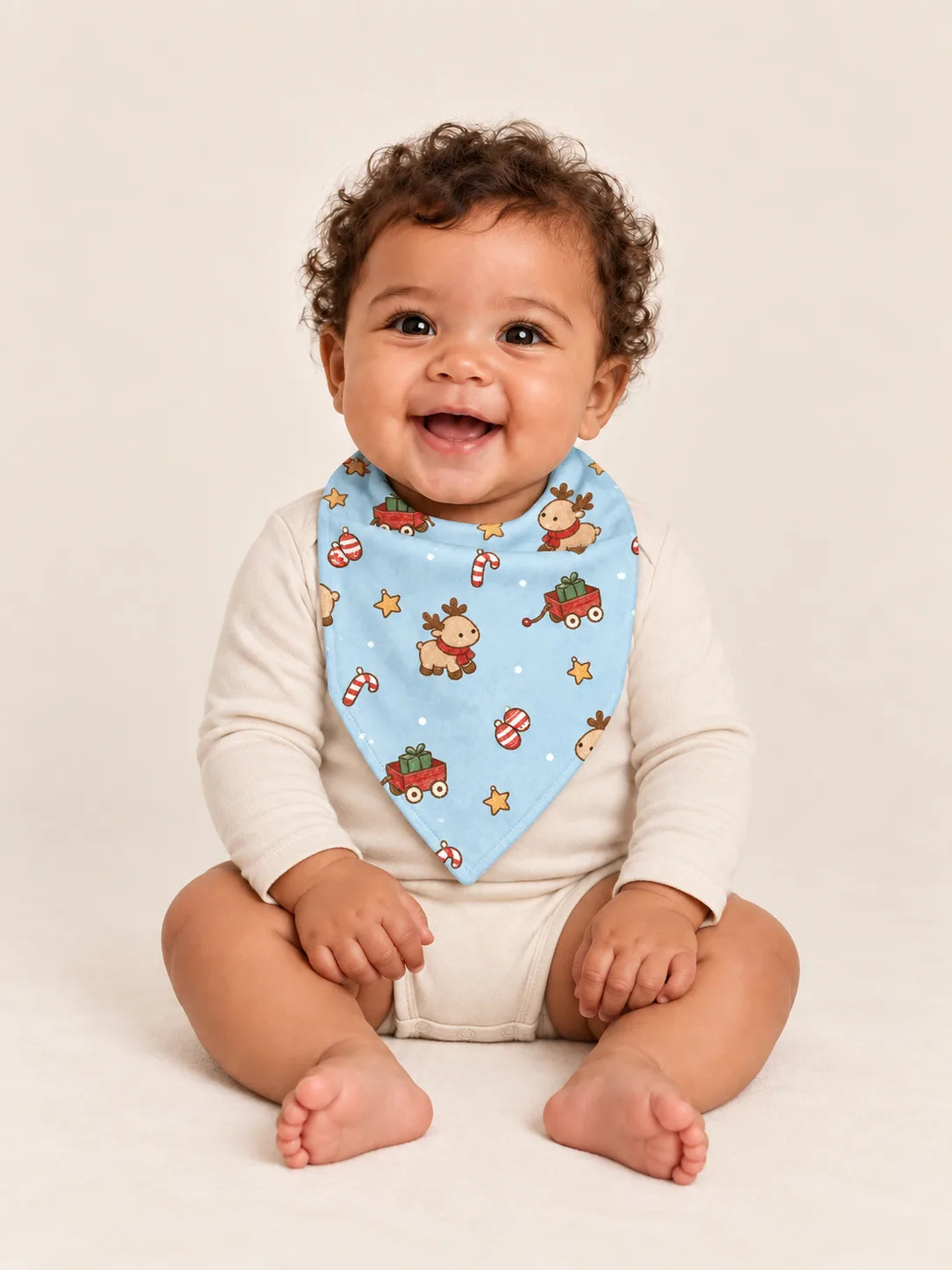 Baby wearing the MossiBaby Reindeer Ride bandana bib with an ivory long-sleeve bodysuit