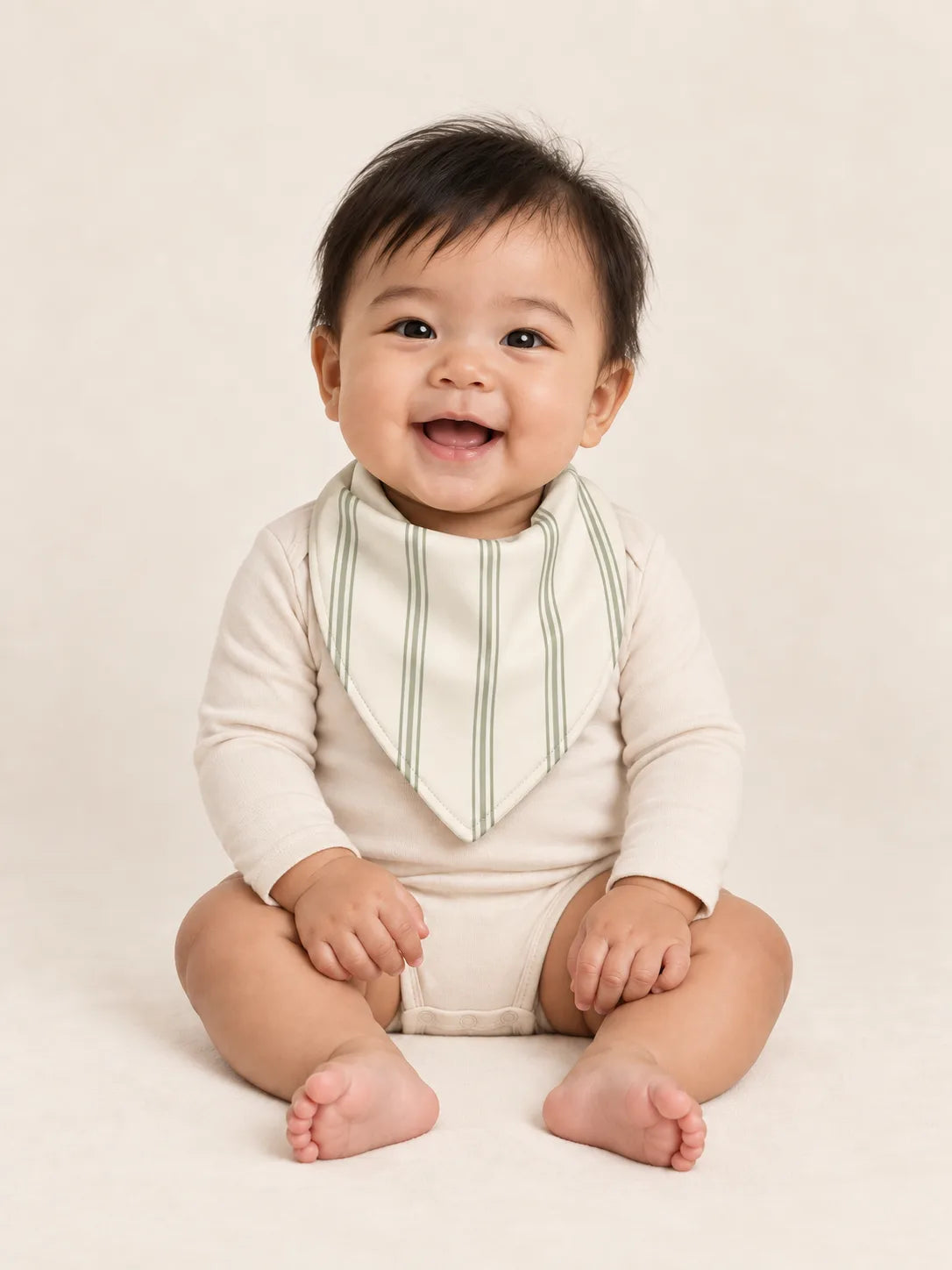 Baby wearing the MossiBaby Sage Stripe bandana bib with an ivory long-sleeve bodysuit