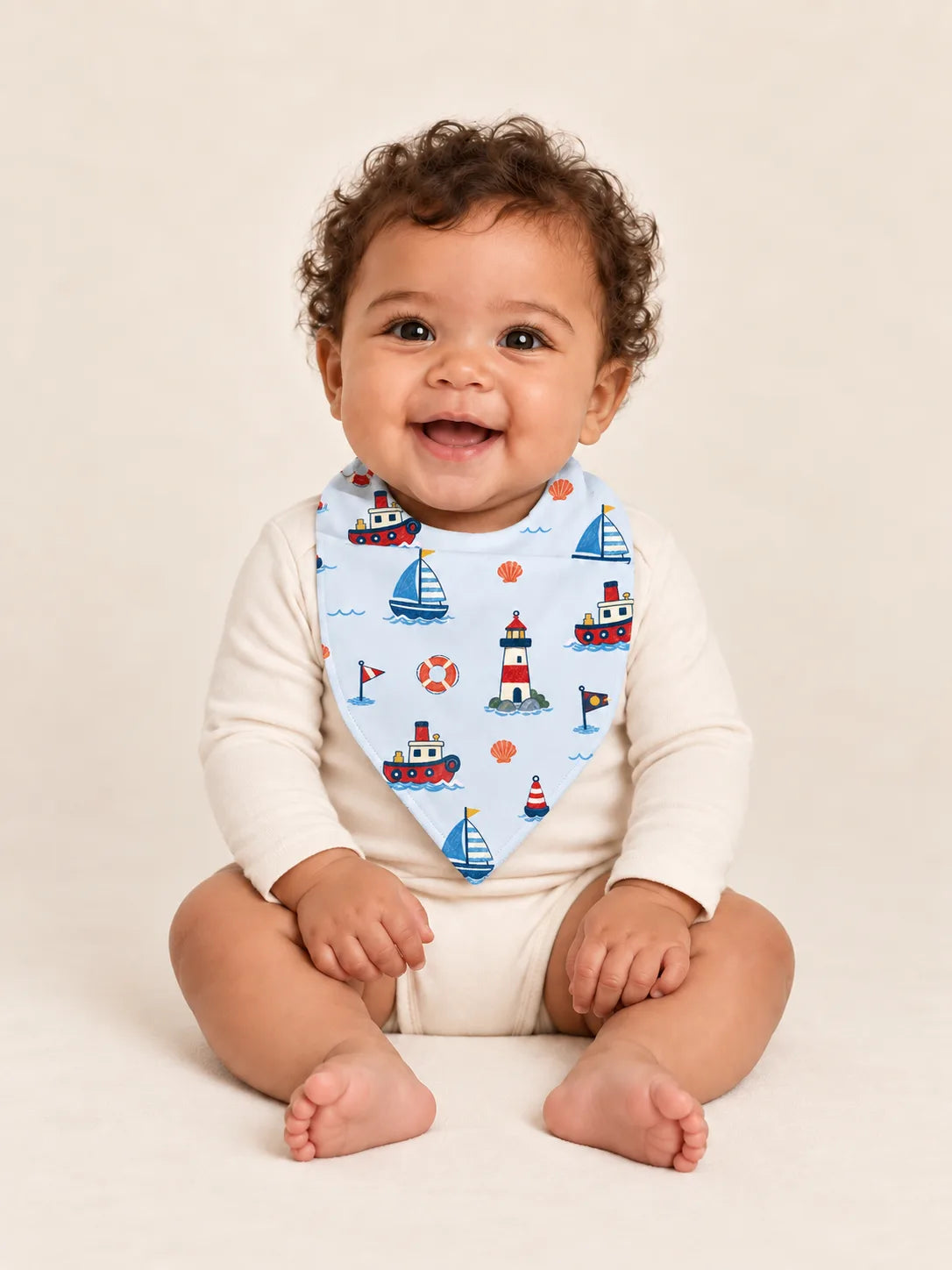 Baby wearing the MossiBaby Sail Away bandana bib with an ivory long-sleeve bodysuit