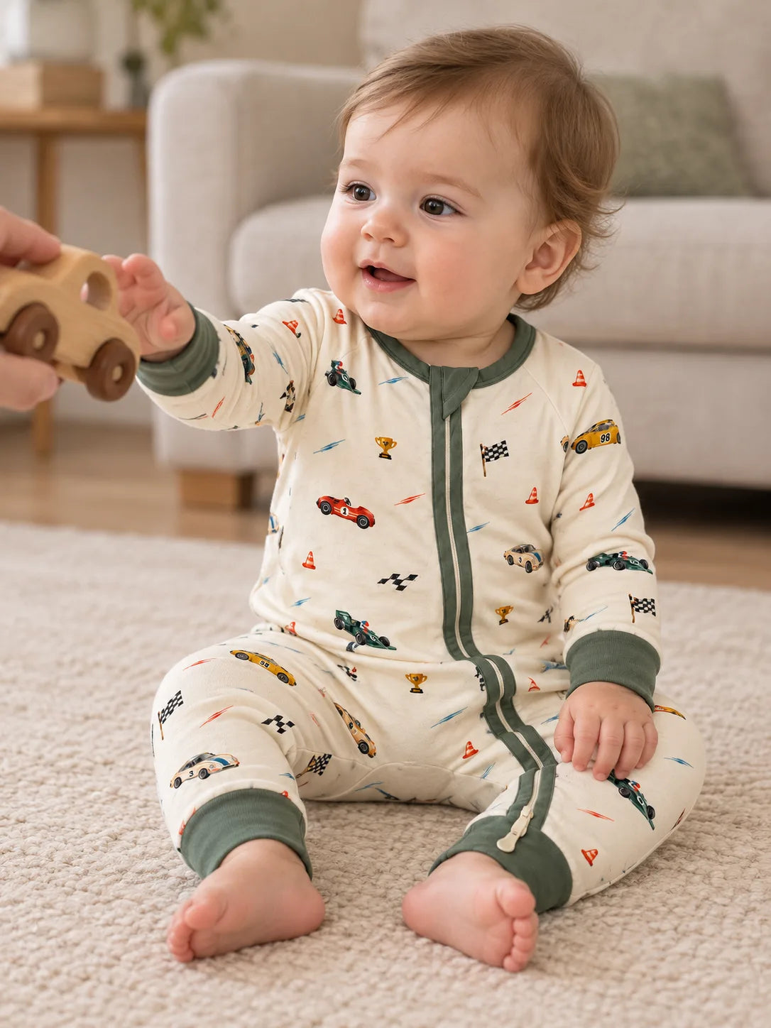 Baby wearing the Vintage Racers bamboo zipper romper while reaching toward a toy car at home.
