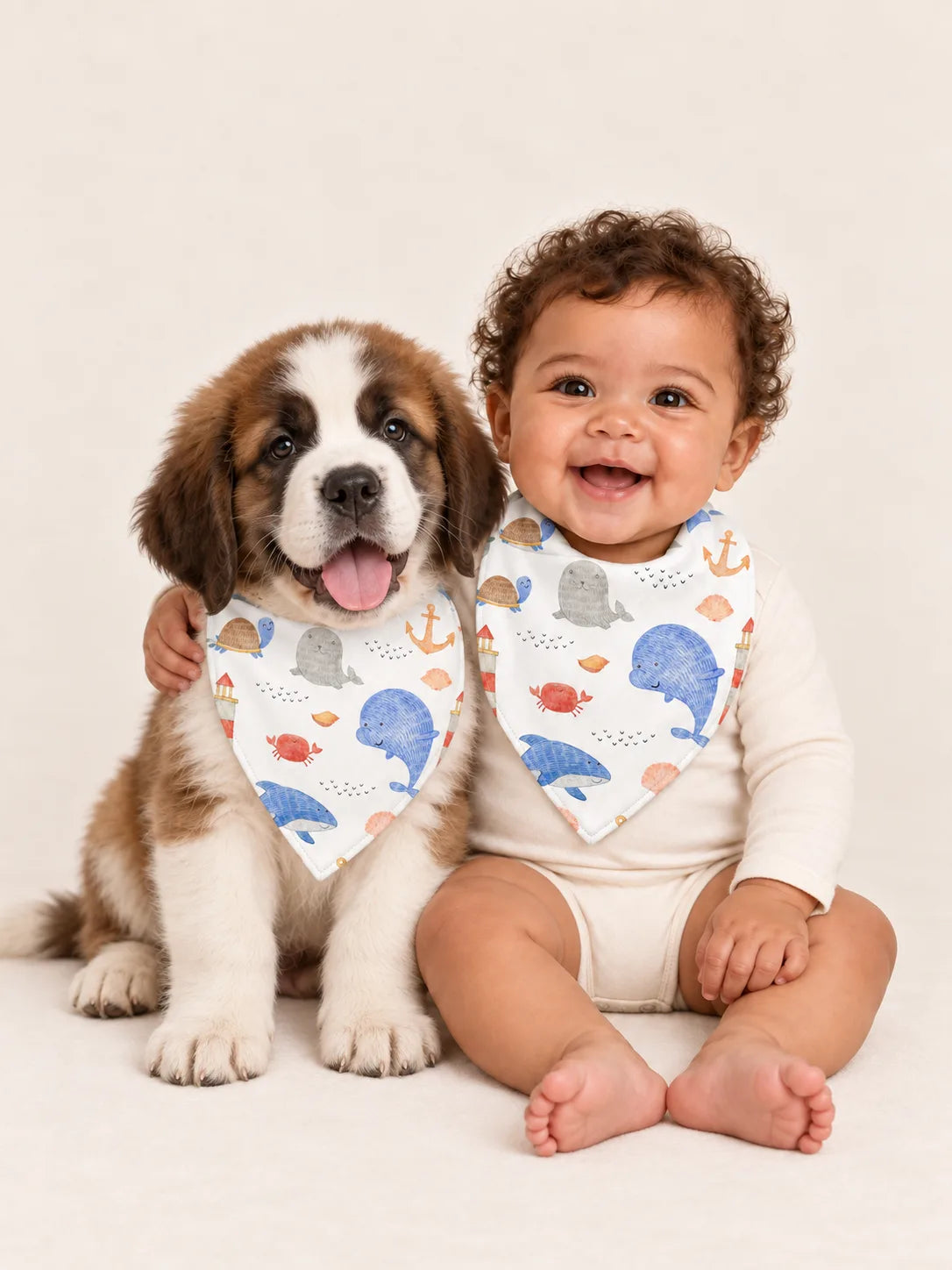 Baby and Saint Bernard puppy wearing matching MossiBaby Whale Harbor bandana bibs