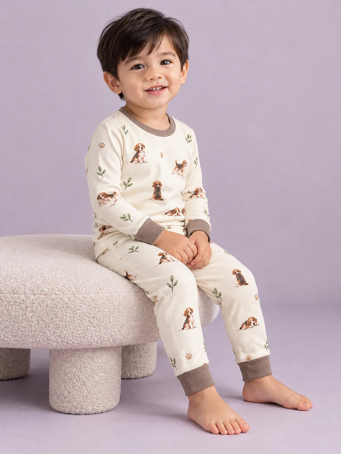 Child wearing the MossiBaby beagle buddies long sleeve pajama set against a pale studio backdrop