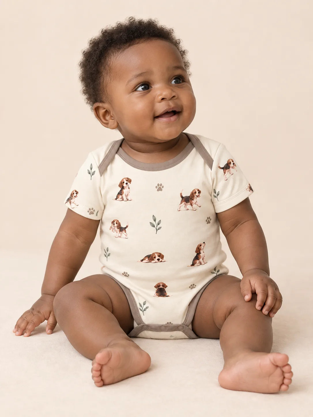 Baby wearing the MossiBaby beagle buddies short sleeve bodysuit against a pale studio backdrop