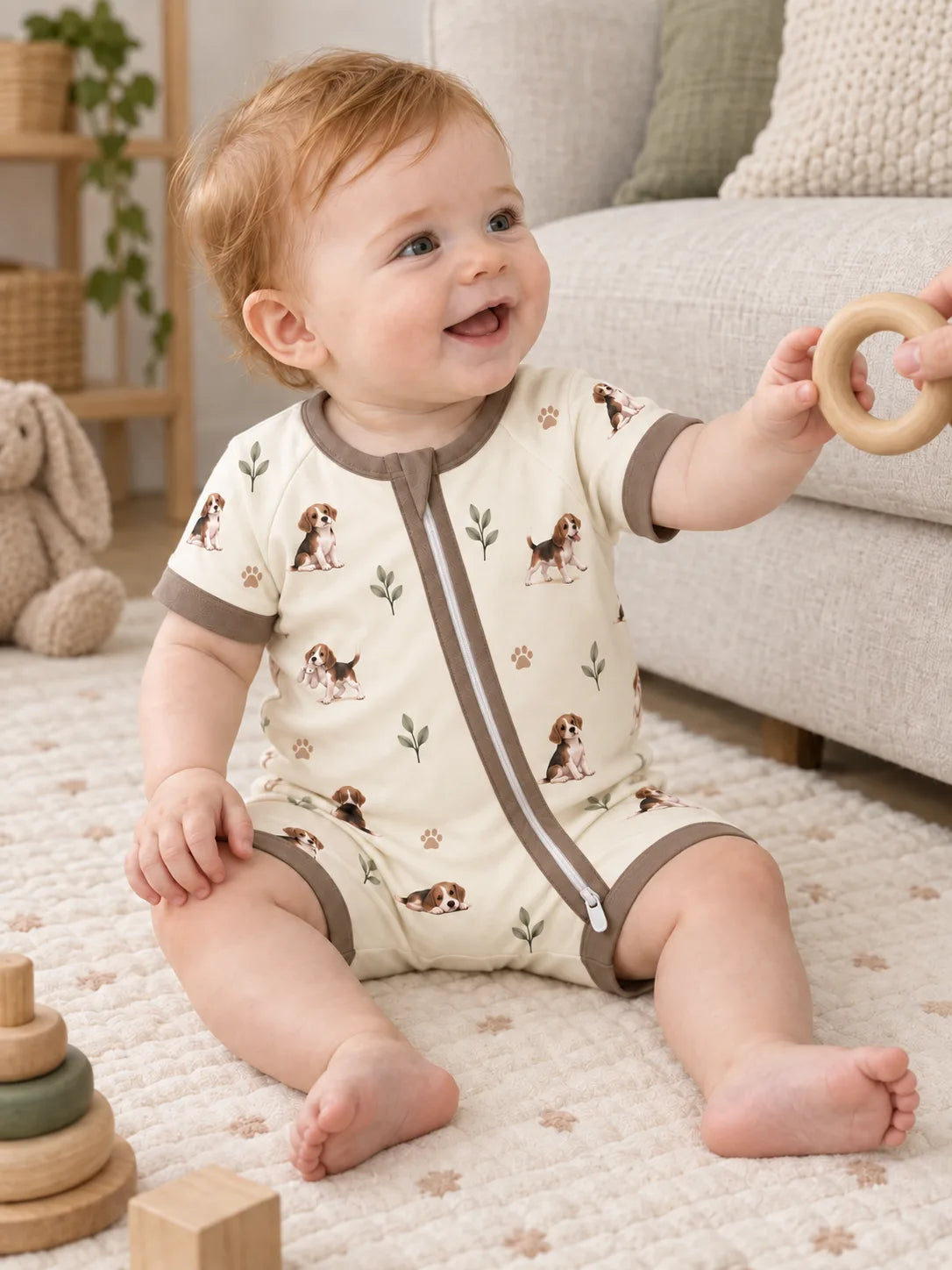 Baby wearing the MossiBaby beagle buddies shorty romper in an indoor lifestyle scene