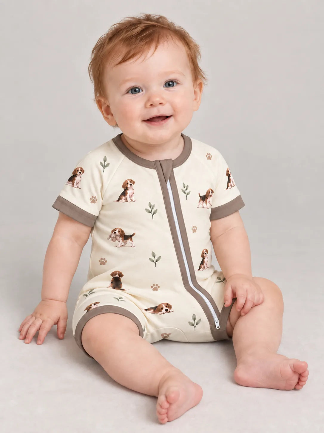 Baby wearing the MossiBaby beagle buddies shorty romper against a pale studio backdrop