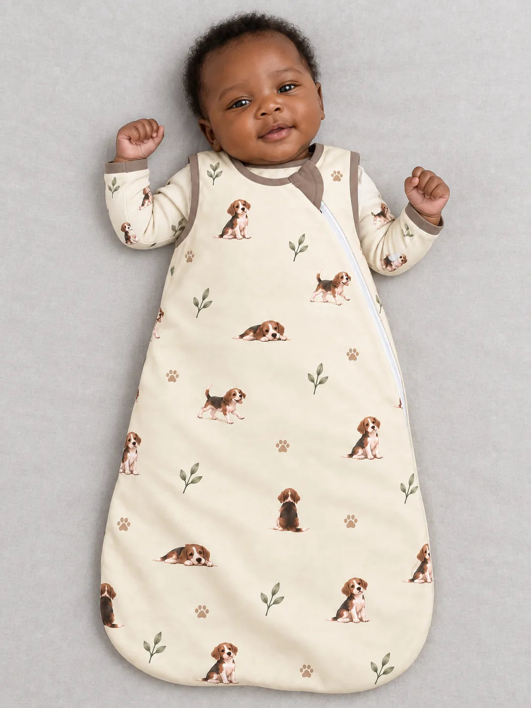 Baby wearing the MossiBaby beagle buddies sleep bag against a pale studio backdrop
