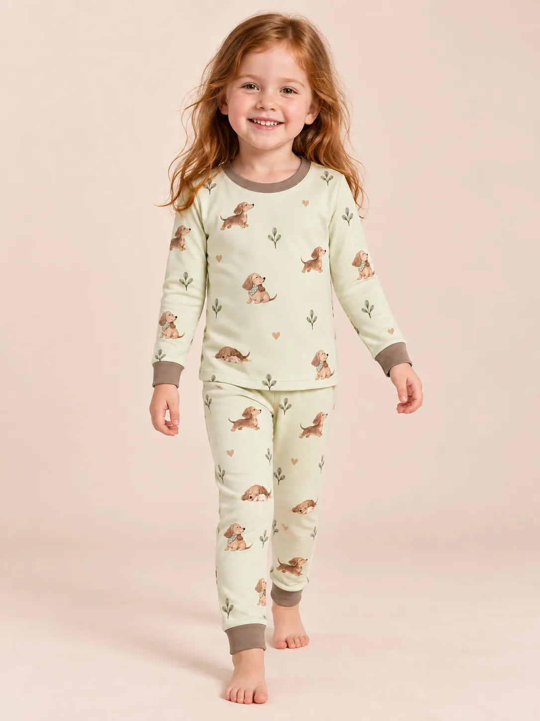 Child wearing the MossiBaby dachshund meadow long sleeve pajama set against a pale studio backdrop