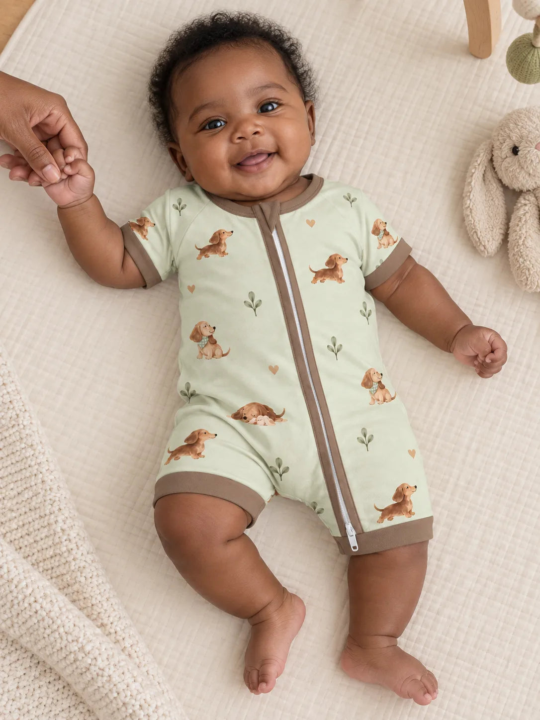 Baby wearing the MossiBaby dachshund meadow shorty romper in an indoor lifestyle scene