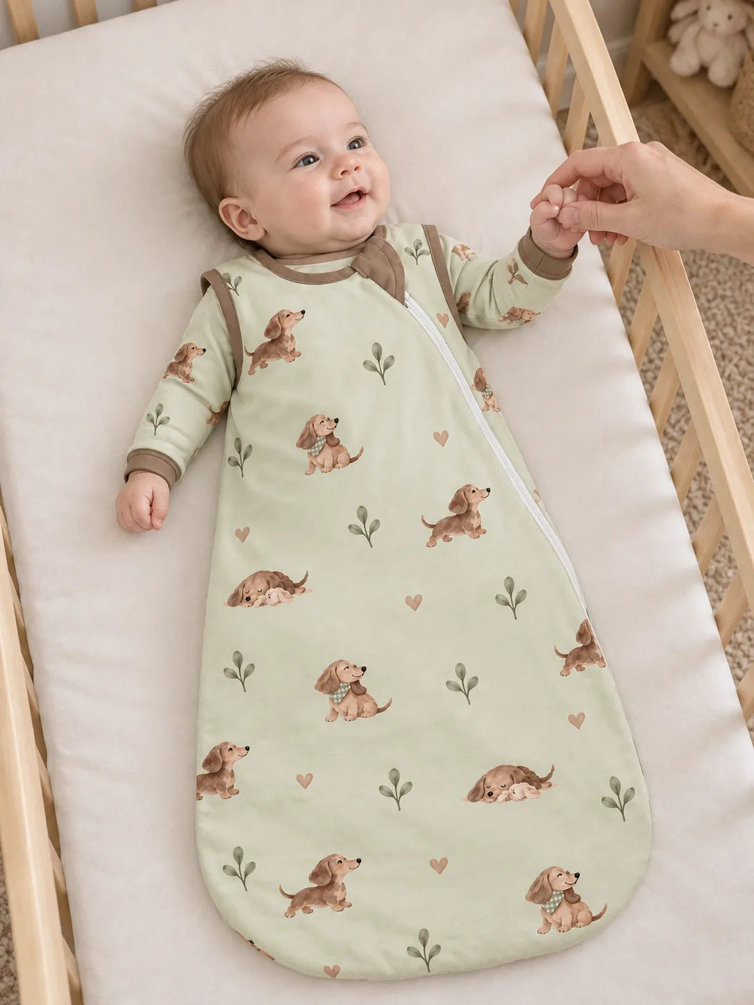 Baby wearing the MossiBaby dachshund meadow sleep bag in an indoor lifestyle scene