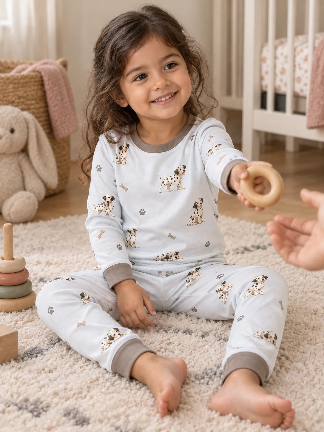 Child wearing the MossiBaby dalmatian days long sleeve pajama set in an indoor lifestyle scene