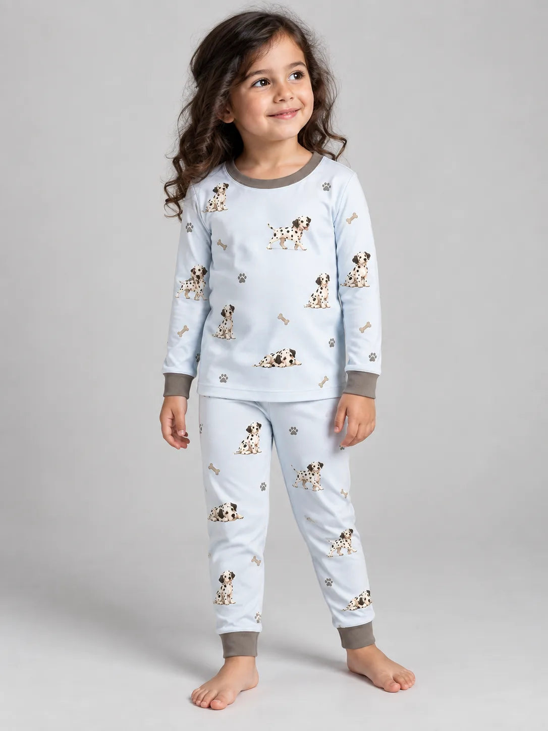 Child wearing the MossiBaby dalmatian days long sleeve pajama set against a pale studio backdrop