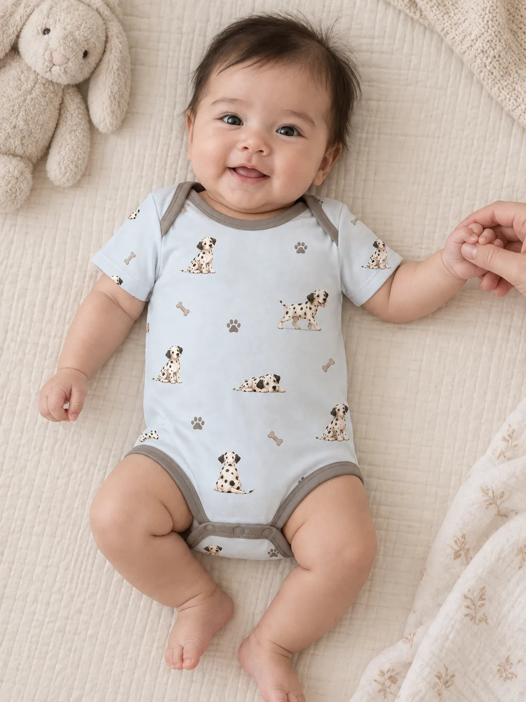 Baby wearing the MossiBaby dalmatian days short sleeve bodysuit in an indoor lifestyle scene