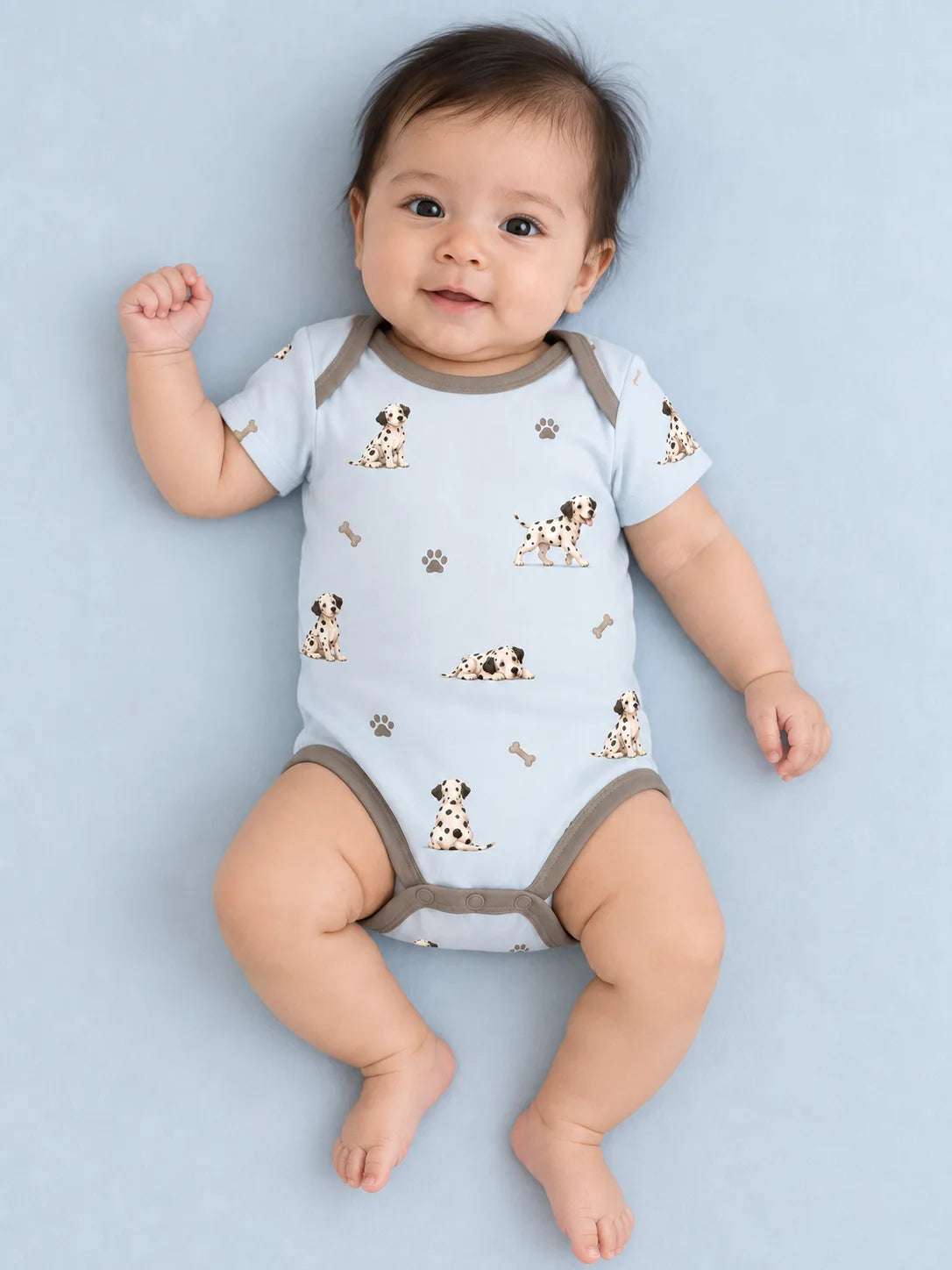 Baby wearing the MossiBaby dalmatian days short sleeve bodysuit against a pale studio backdrop