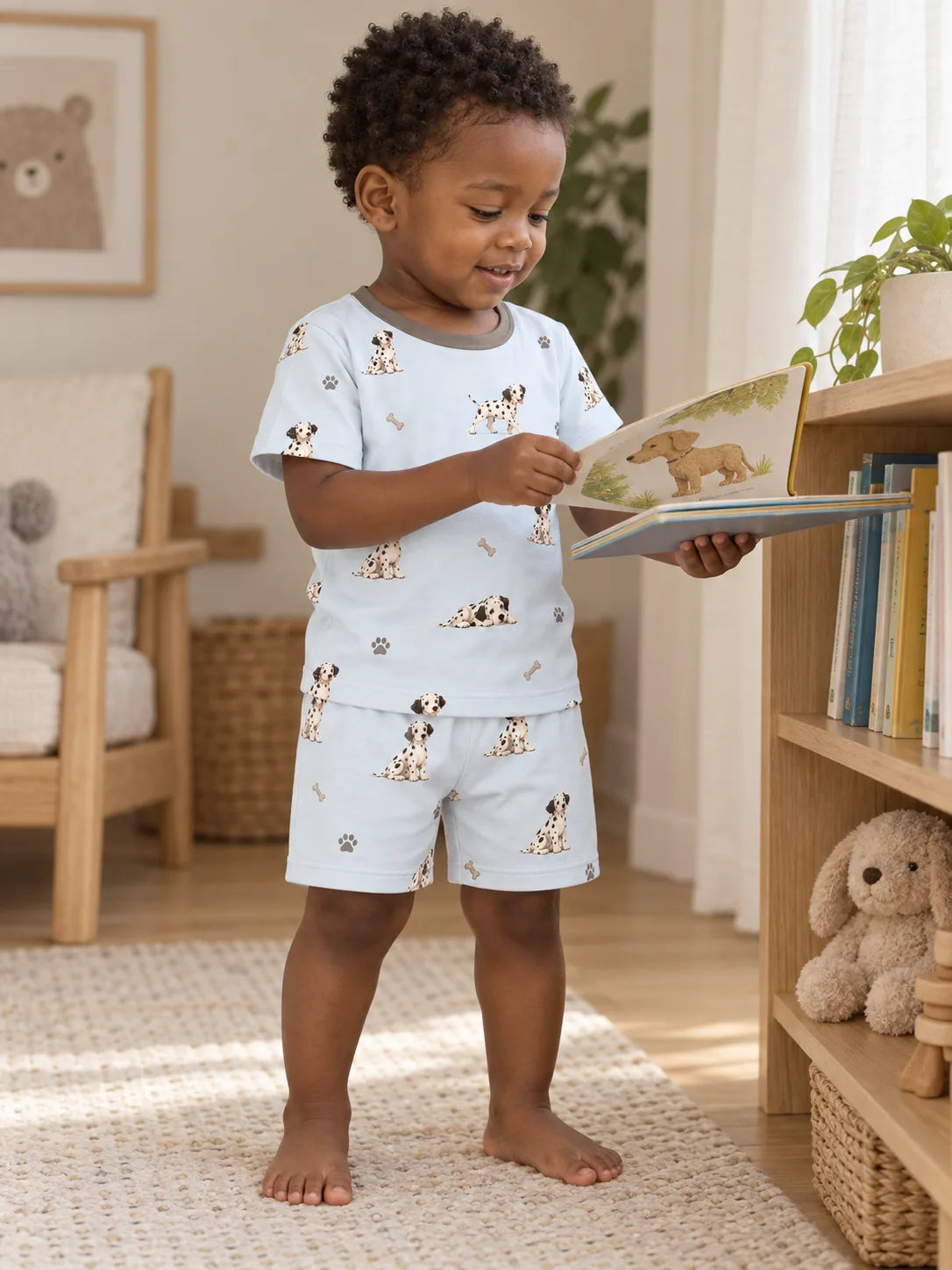 Child wearing the MossiBaby dalmatian days short sleeve pajama set in an indoor lifestyle scene