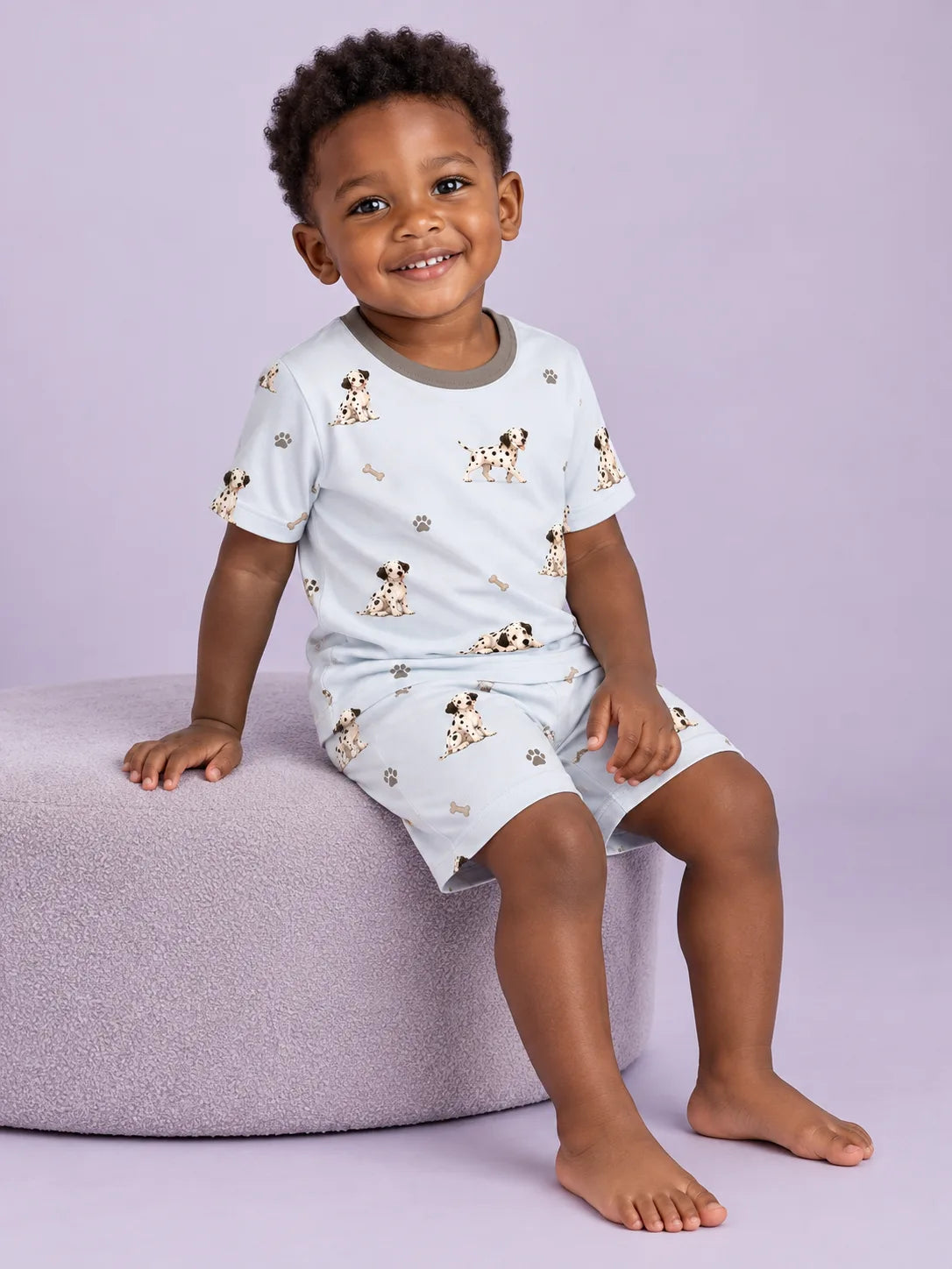 Child wearing the MossiBaby dalmatian days short sleeve pajama set against a pale studio backdrop
