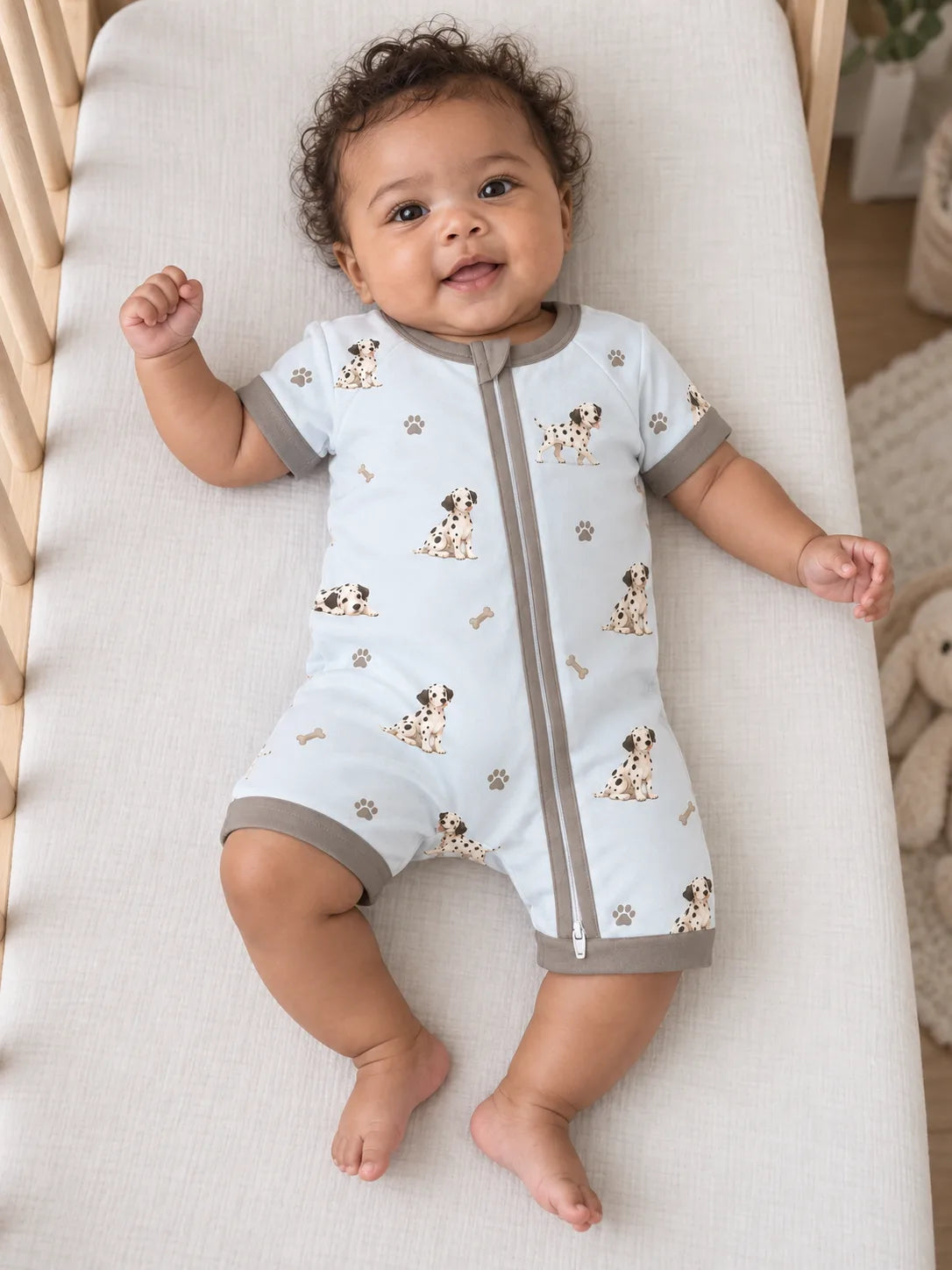 Baby wearing the MossiBaby dalmatian days shorty romper in an indoor lifestyle scene