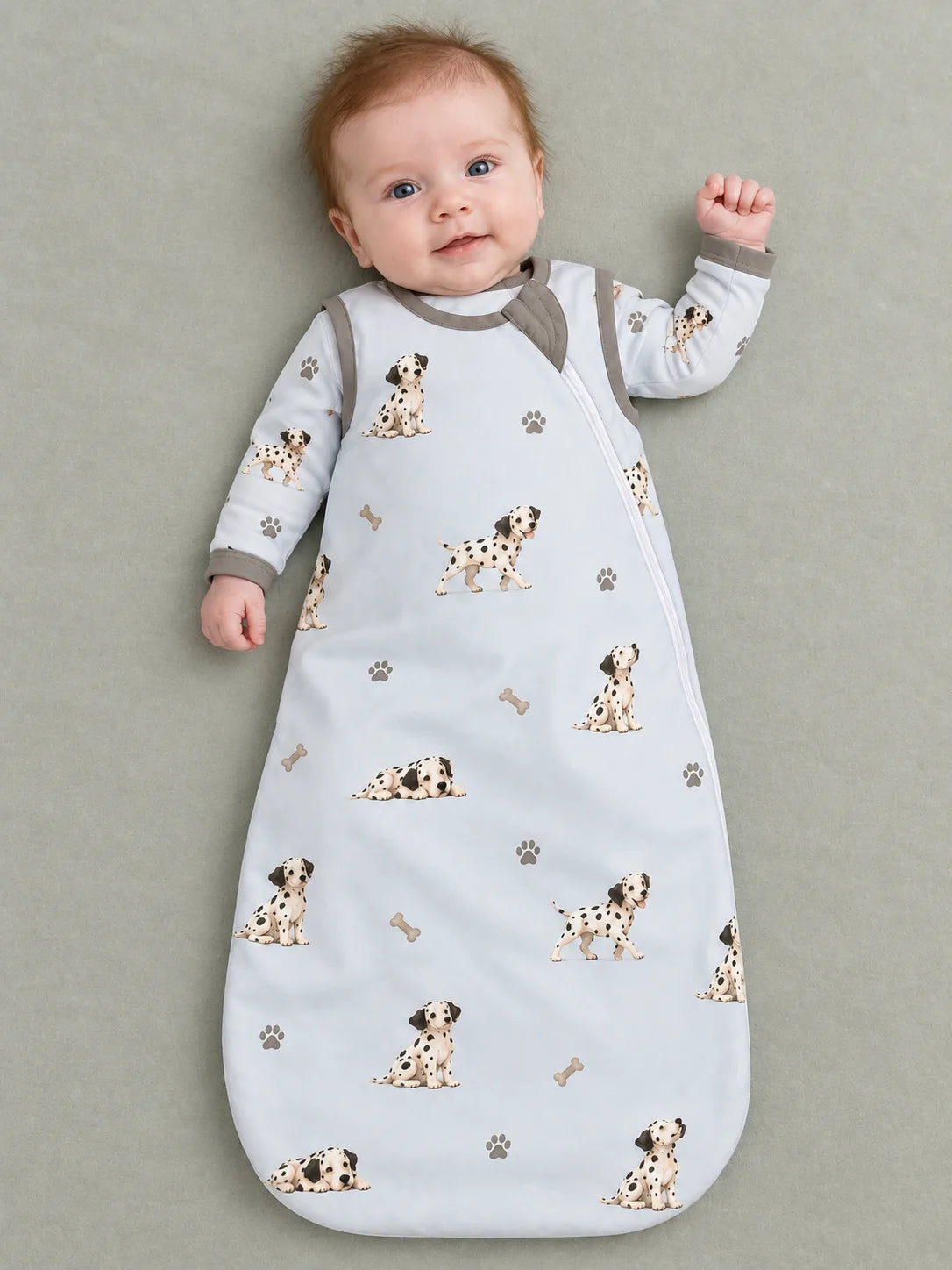 Baby wearing the MossiBaby dalmatian days sleep bag against a pale studio backdrop
