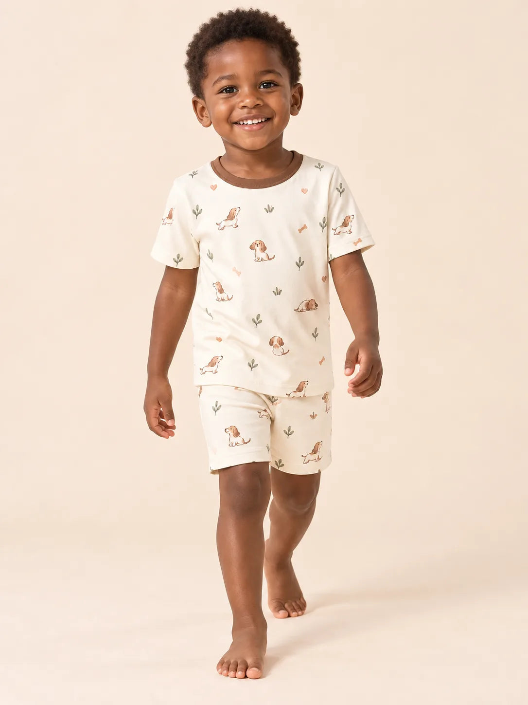 Child wearing the MossiBaby doxie dreams short sleeve pajama set against a pale studio backdrop